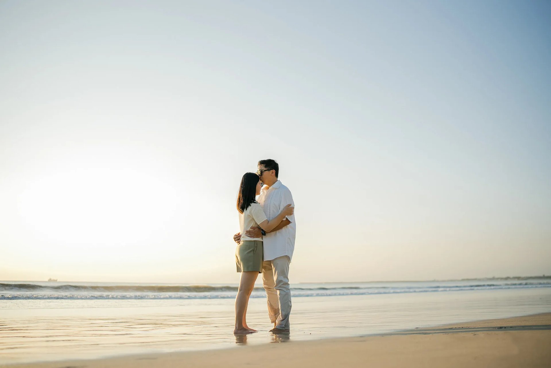 Family embracing on the beach during sunset at InterContinental Bali Resort