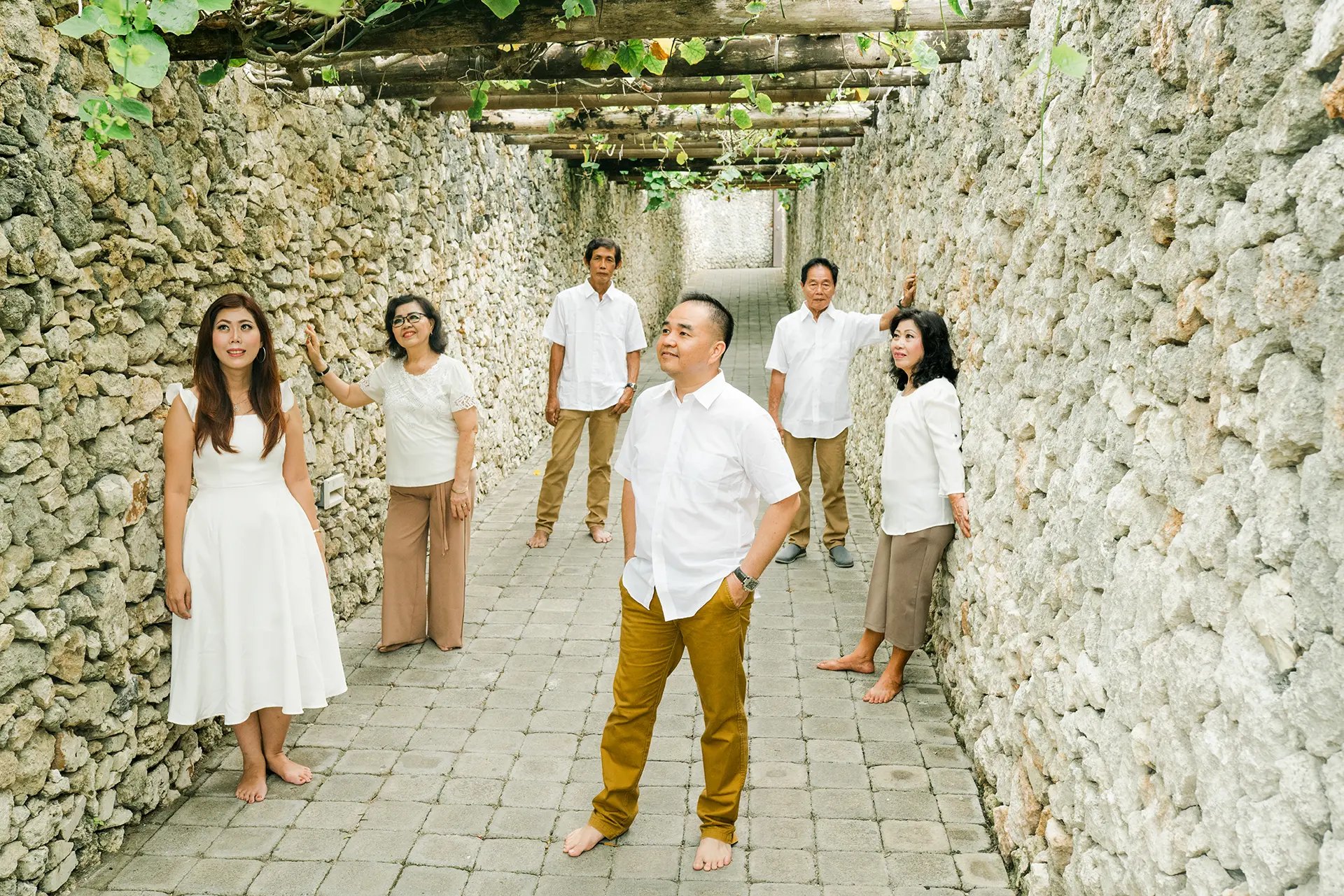 Selly family  through the stone pathway during a luxury family photography session at Karma Kandara Uluwatu Bali  