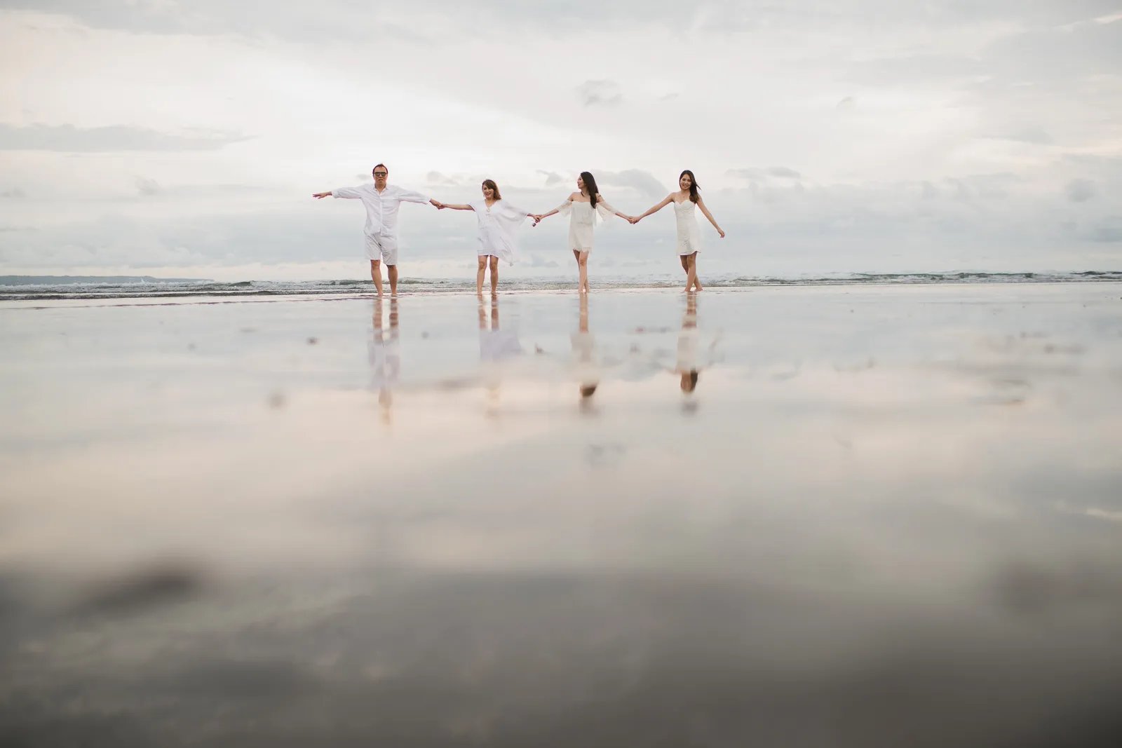 Janice family reflected on the shoreline during a sunset session at Indigo Seminyak Bali