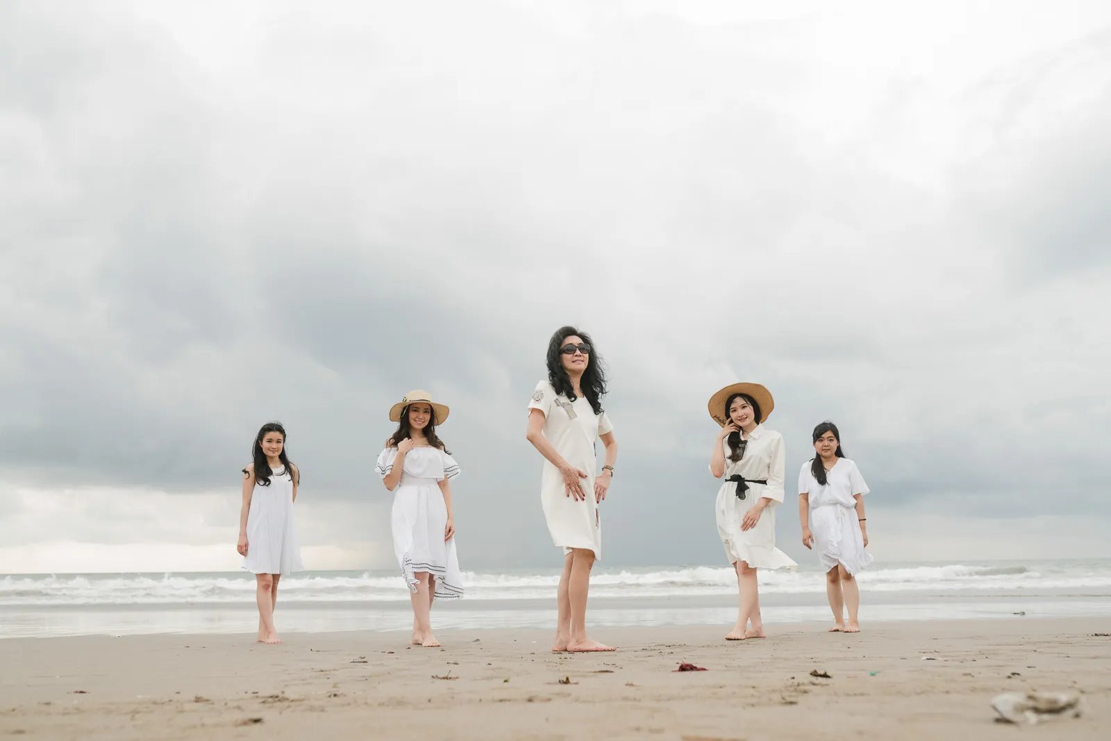 Multigeneration family walking together at Seminyak Beach Bali during natural luxury family photography session.