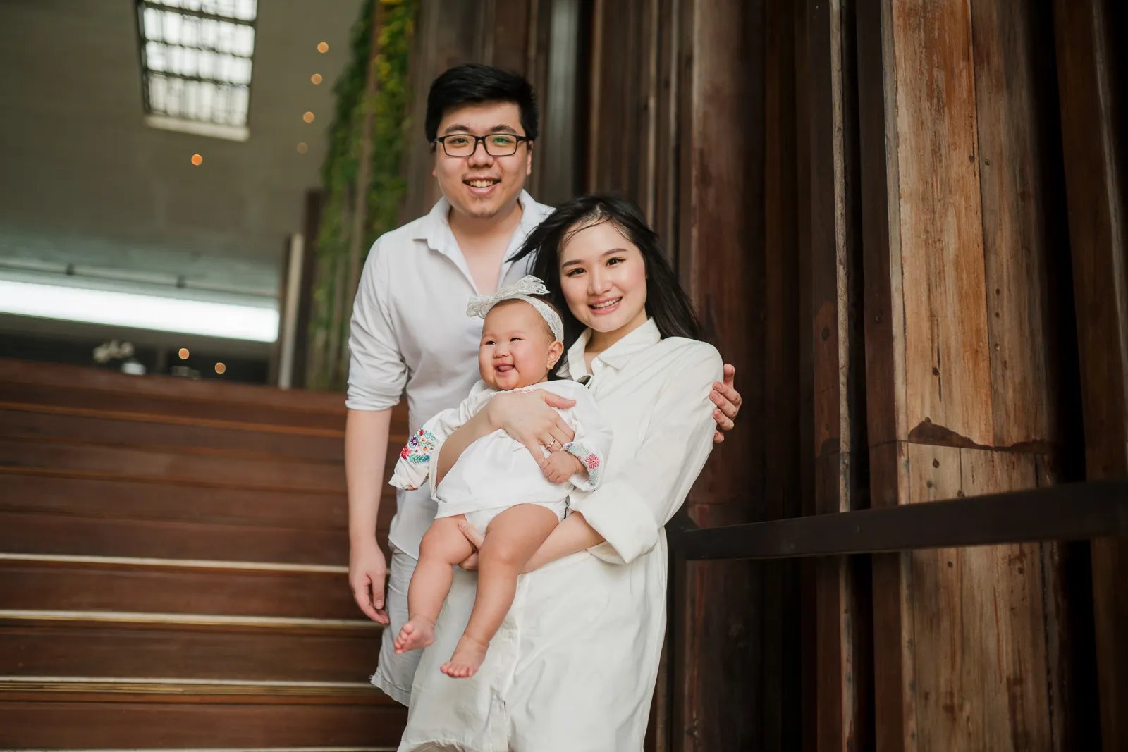 Multigeneration family portrait at Alila Seminyak Bali with parents holding their baby during a relaxed luxury family session
