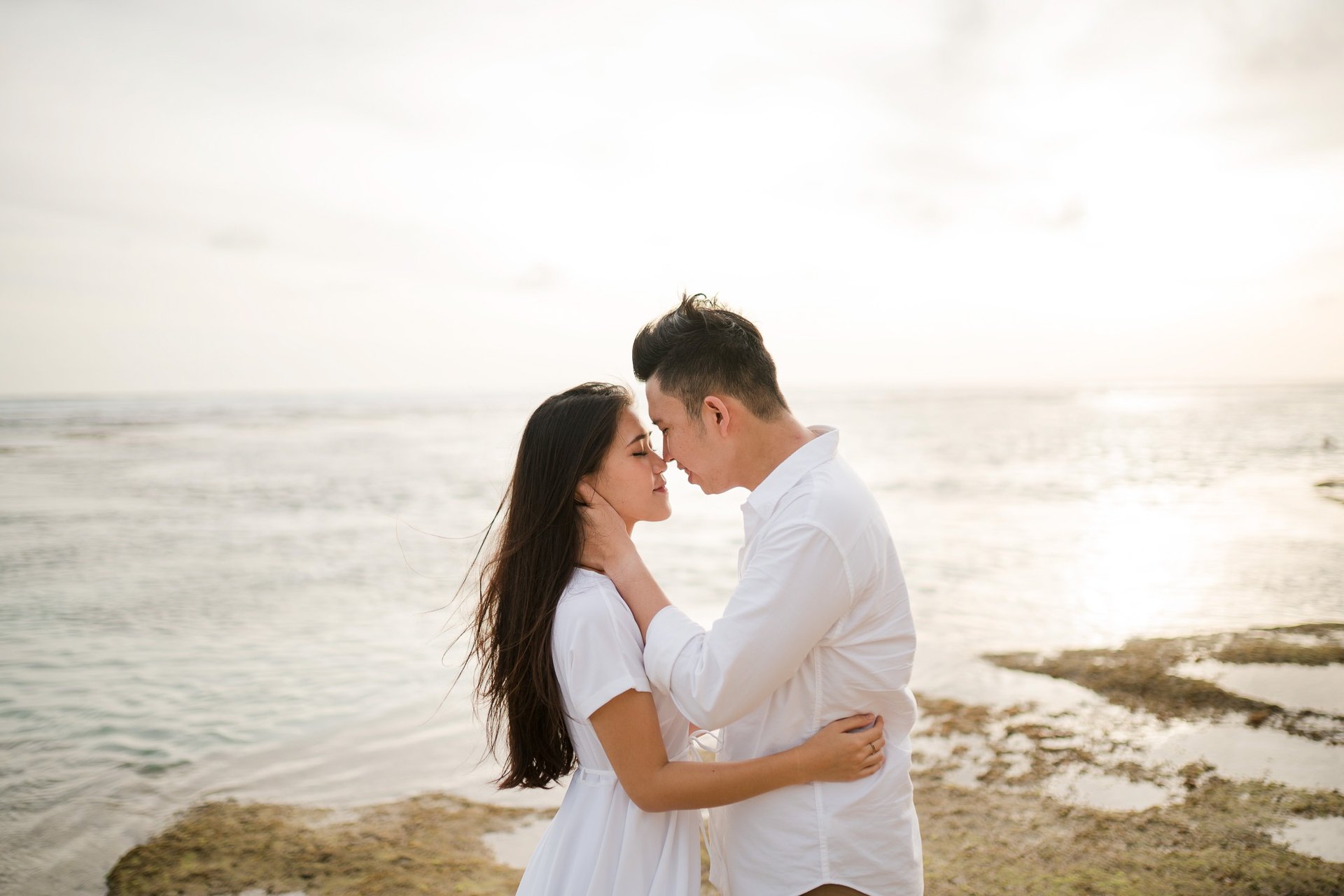 Couple embracing during golden hour proposal session at Melasti Beach Bali