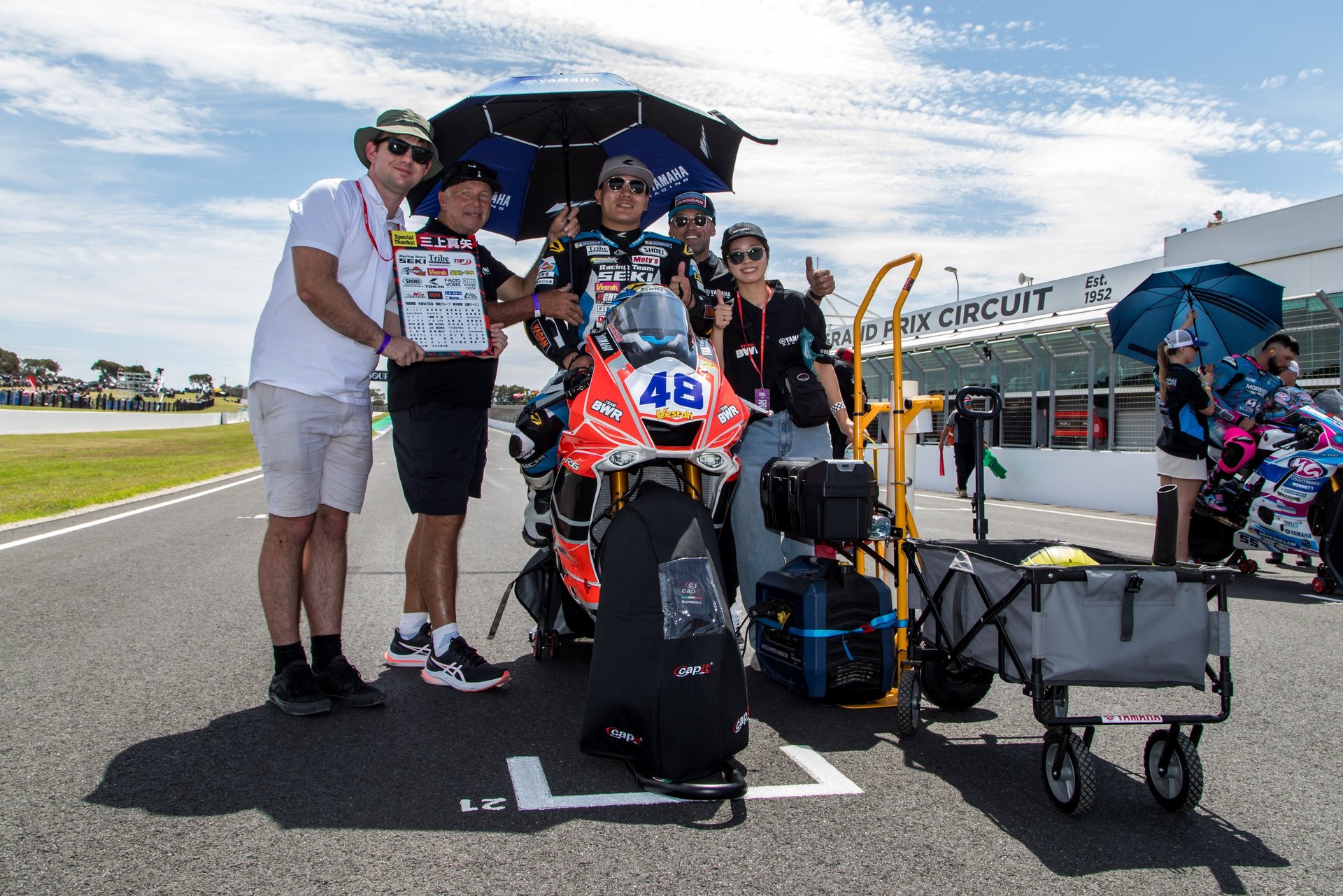 a group of people standing around a motorcycle