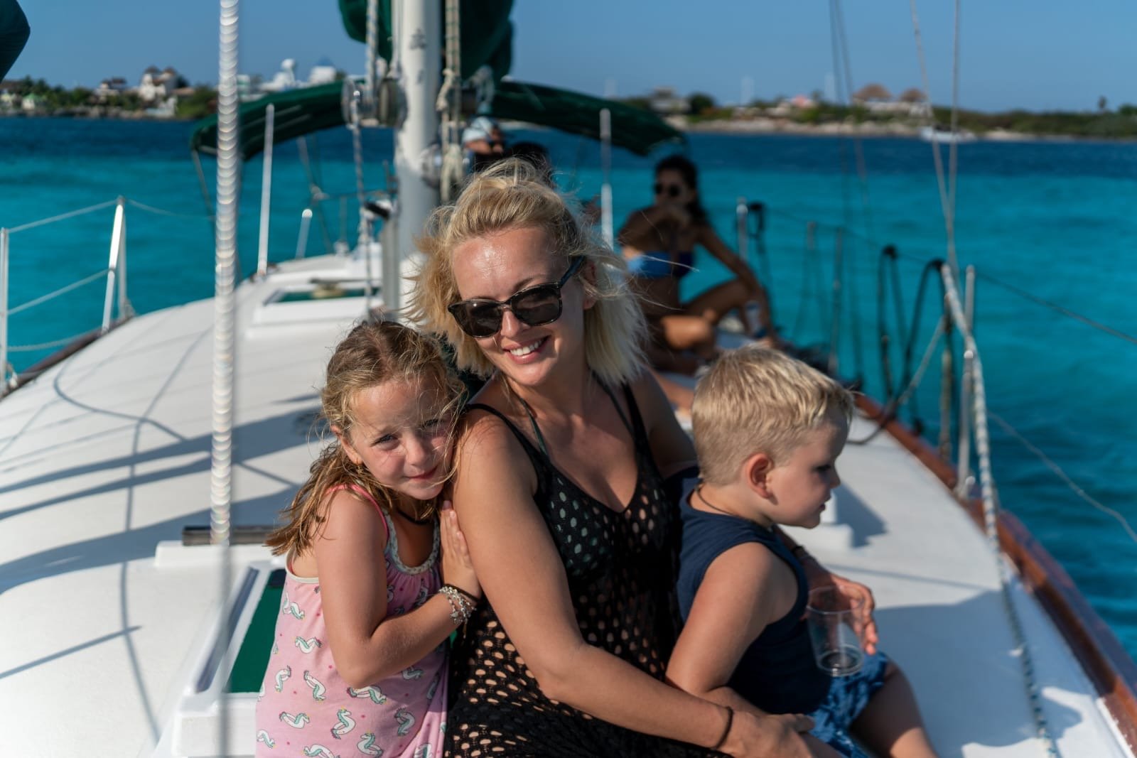 a woman and two children on a boat in cancun 