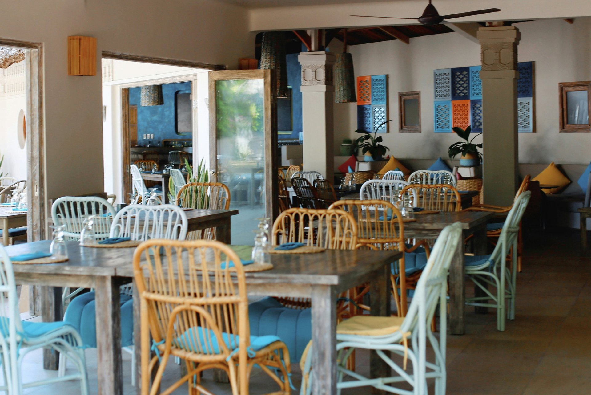 Empty cafe interior in Vietnam with bamboo-style chairs, cushions and simple tables