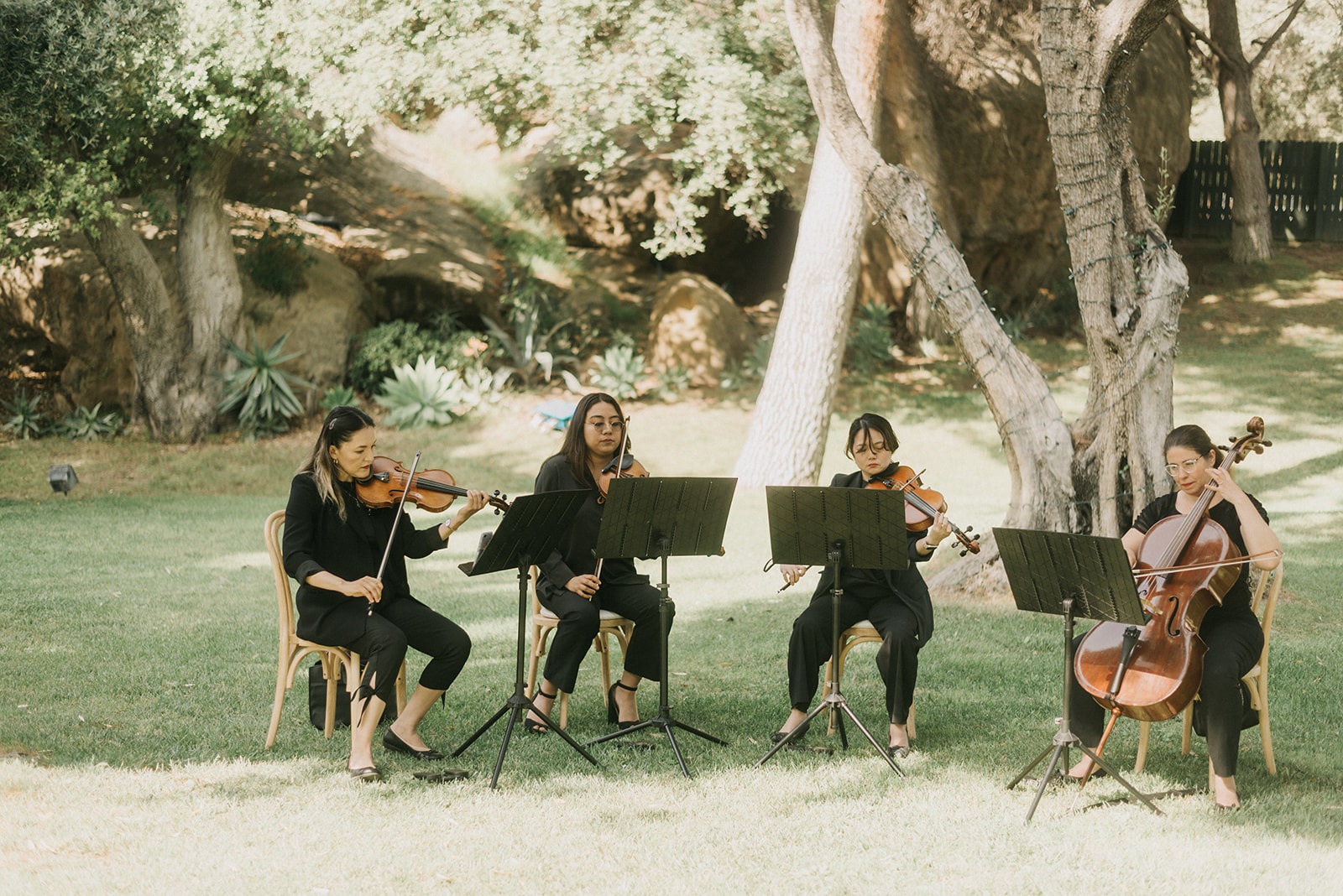 String quartet performing for a wedding ceremony at outdoor venue