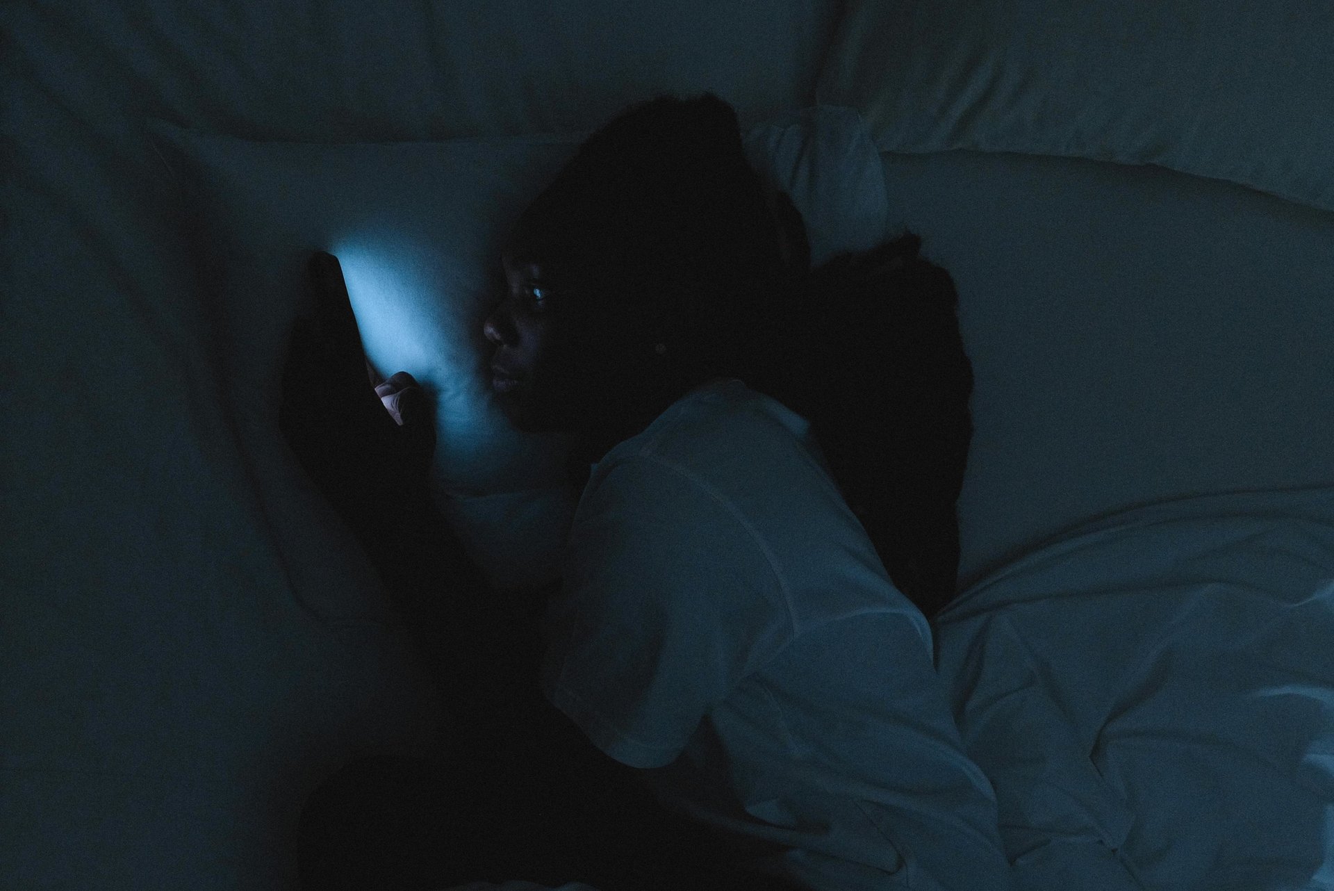 a person laying in bed with a cell phone