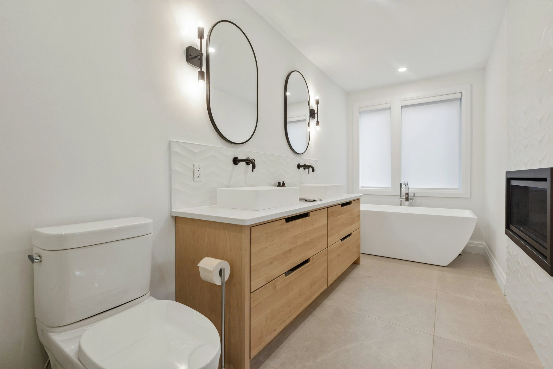 Salle de bain sur mesure avec meuble double vasque en bois clair et baignoire îlot conçue par Baïa Home à Caen