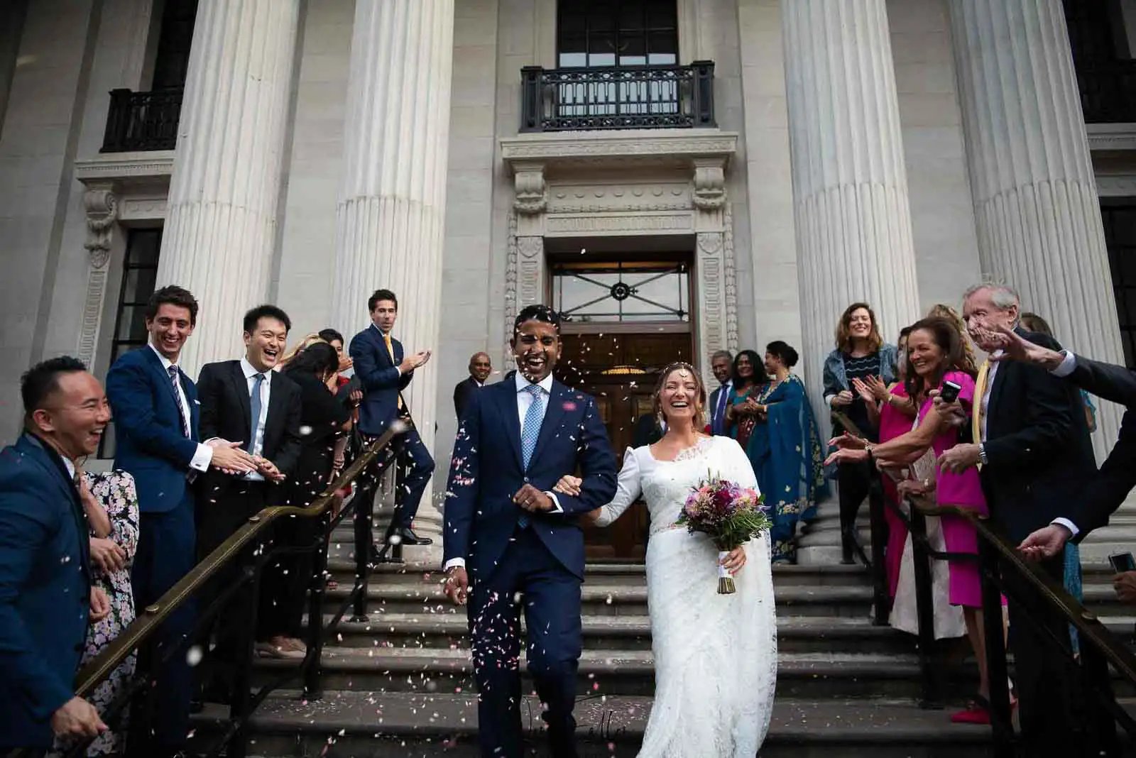 Newly-weds walking down the steps at Old Marylebone Town Hall