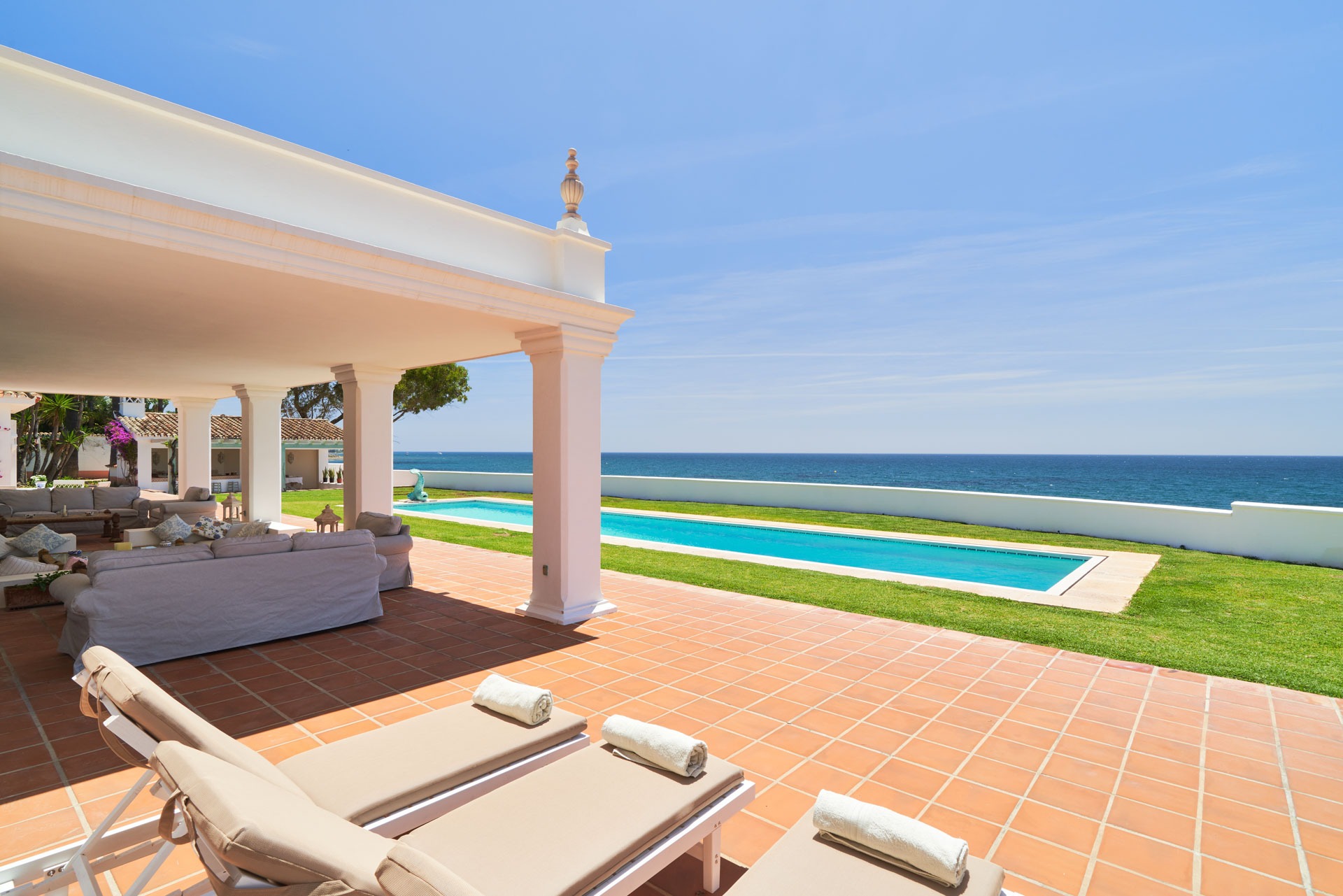 Covered terrace with loungers and beachfront pool