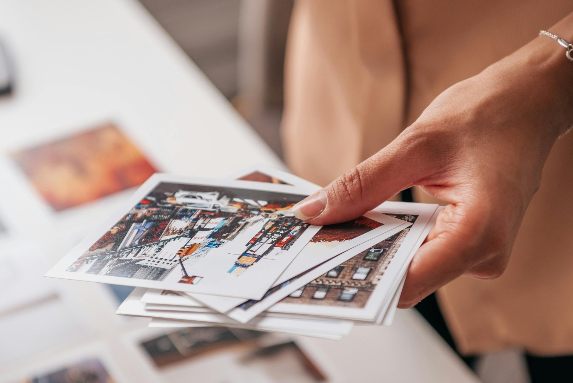 a person holding a bunch of photos doing a choice for the creation of a unique luxury print