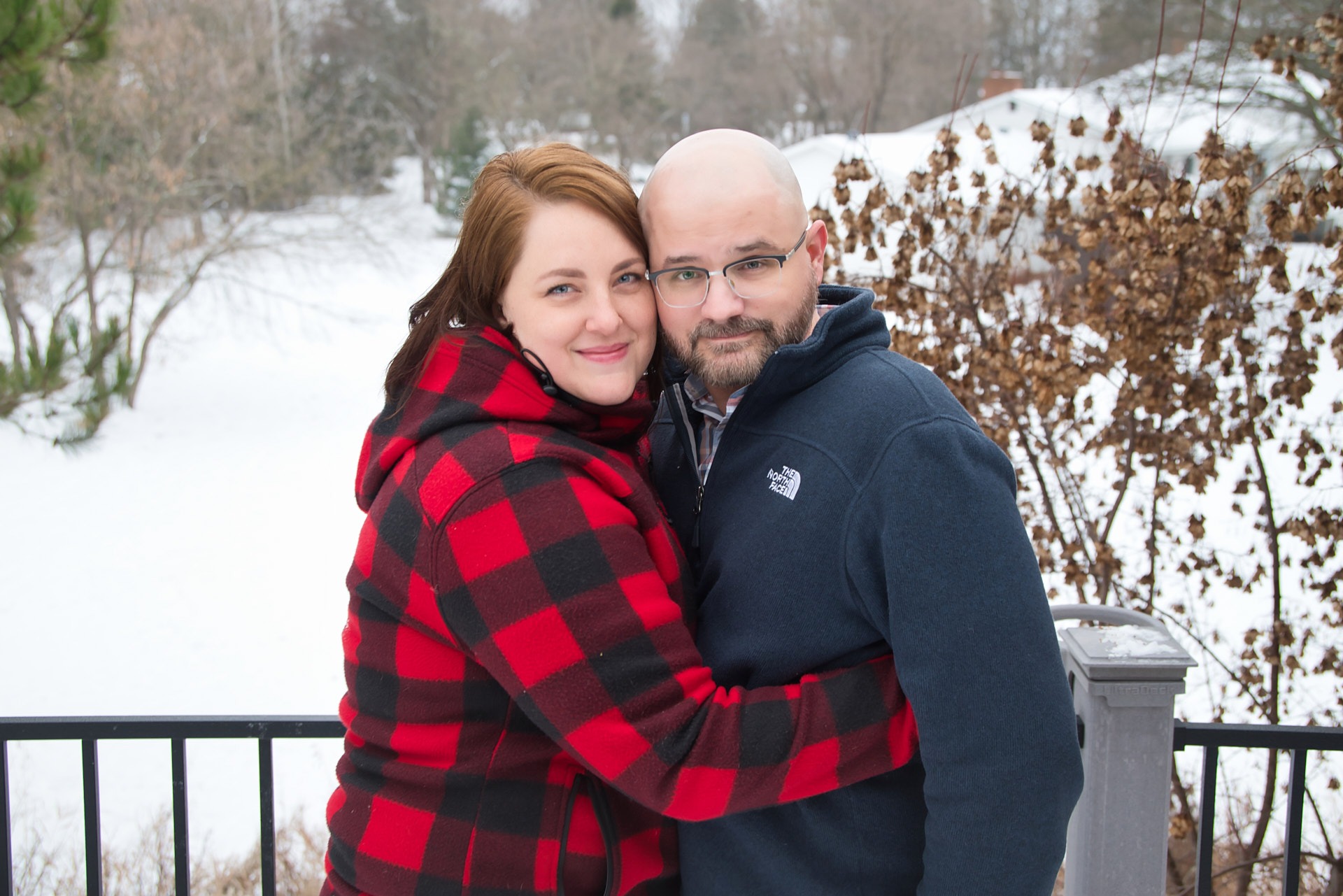 a man and woman standing in the snow