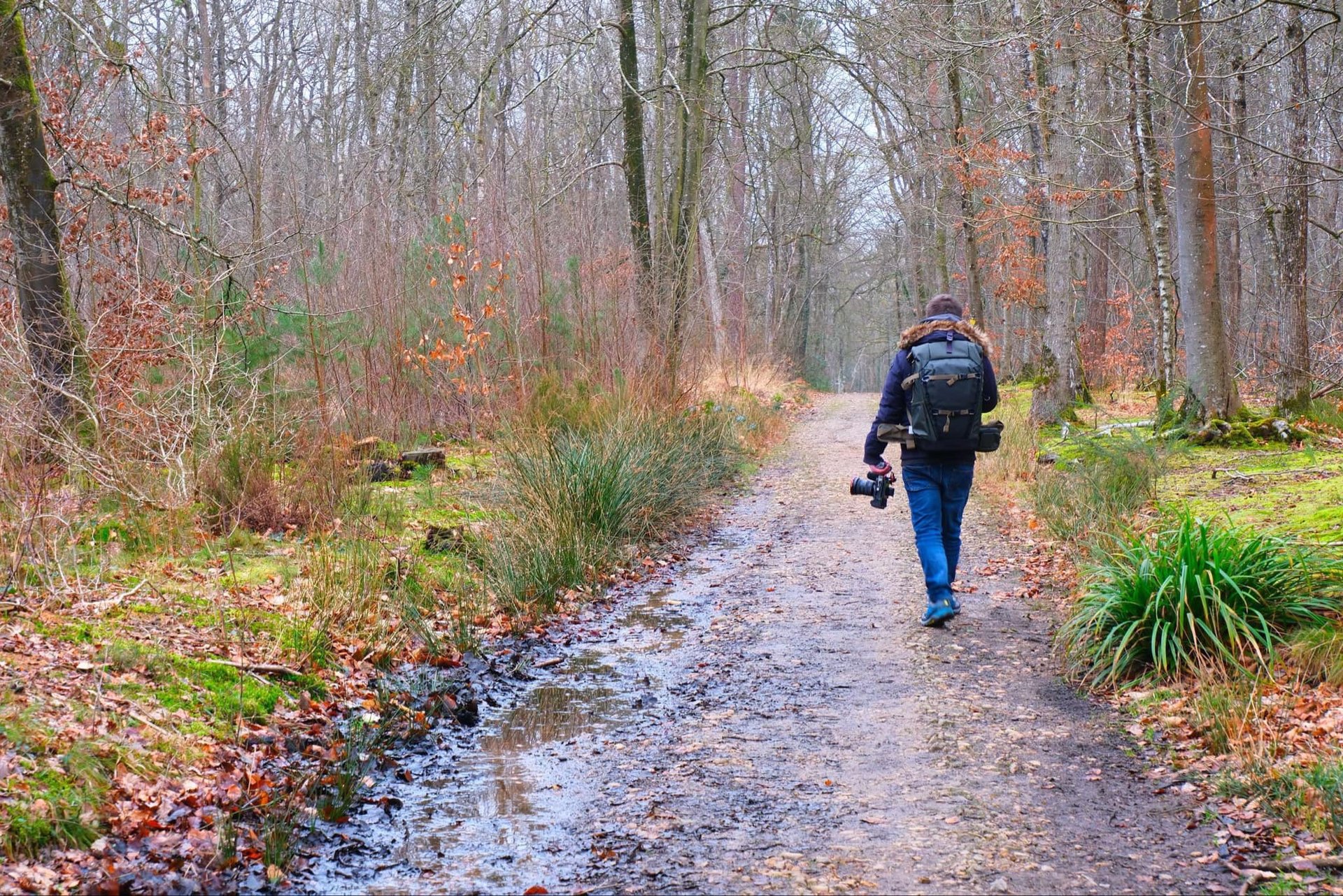 a man walking down a path with a backpack on his back