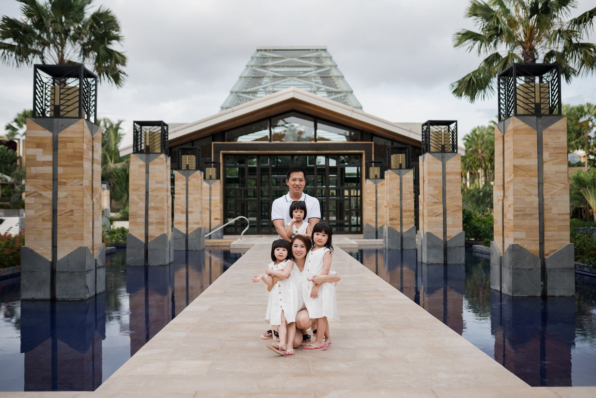 Family portrait at the iconic water reflection entrance of The Mulia Nusa Dua Bali during a Bali family photography session