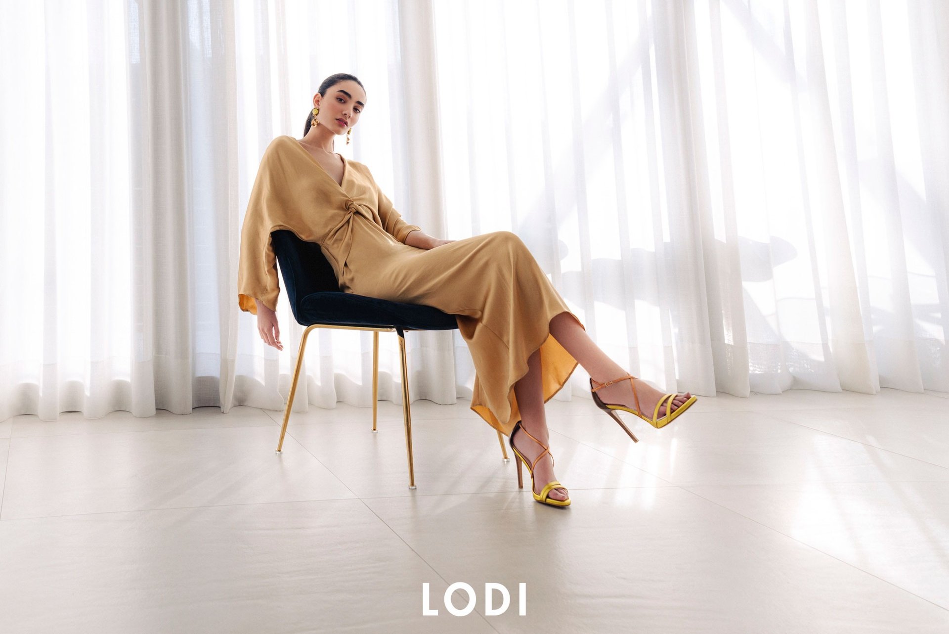 Modelo sentada con tacones de Lodi Shoes