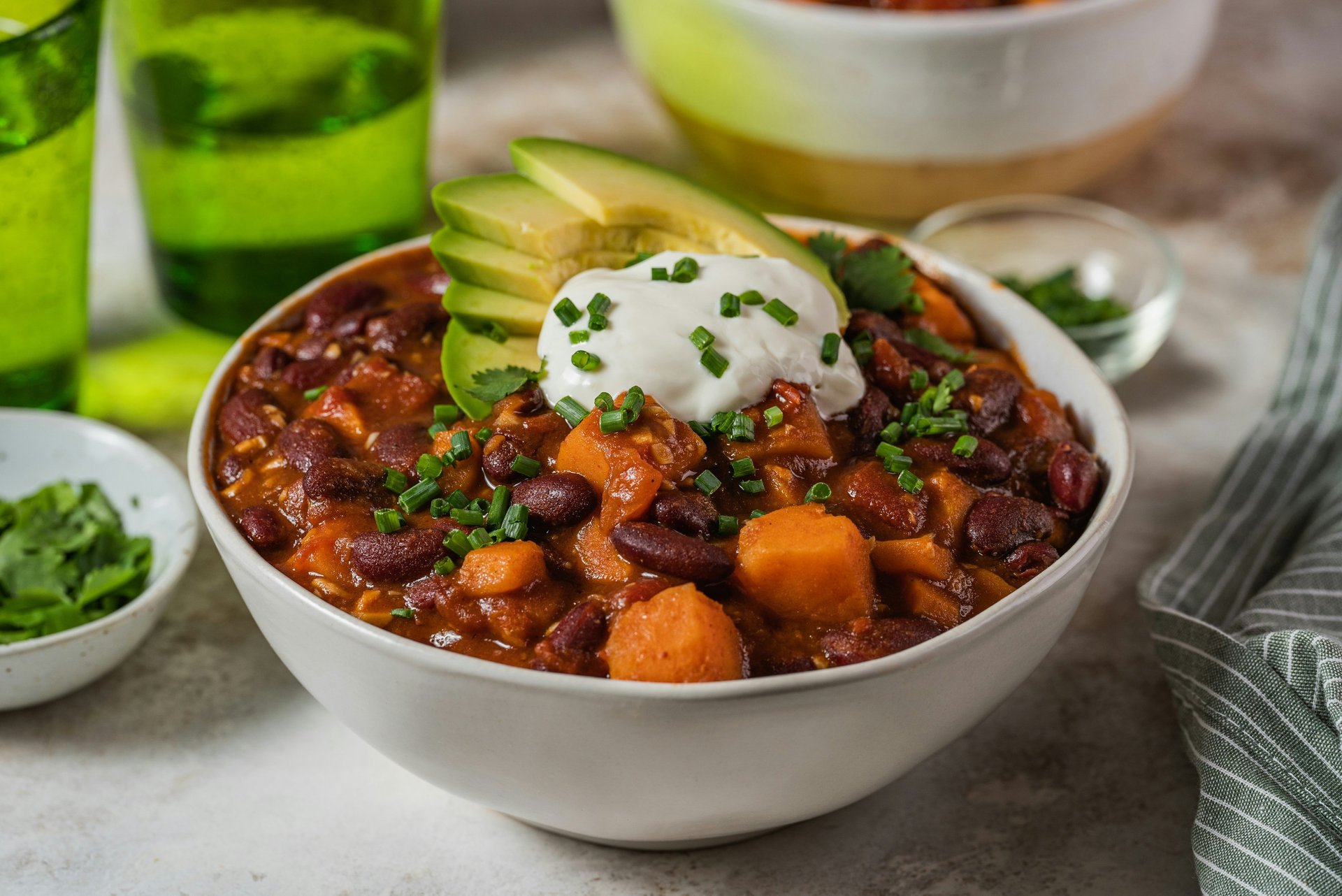 Bowl with vegan chili sin carne with beans, vegetables, vegan topping yogurt and avocado