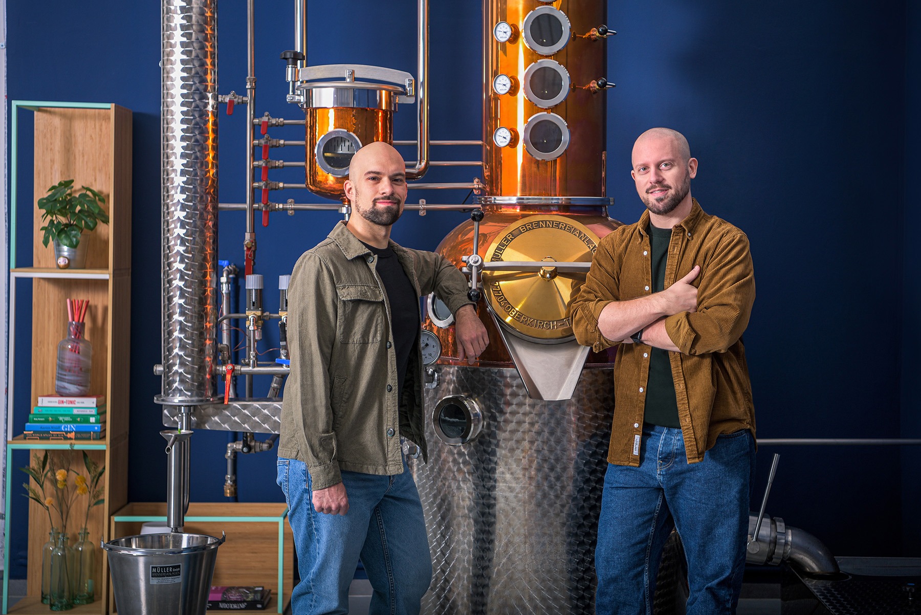 master distiller e designer in posa professionale davanti ad un alambicco di rame e acciaio