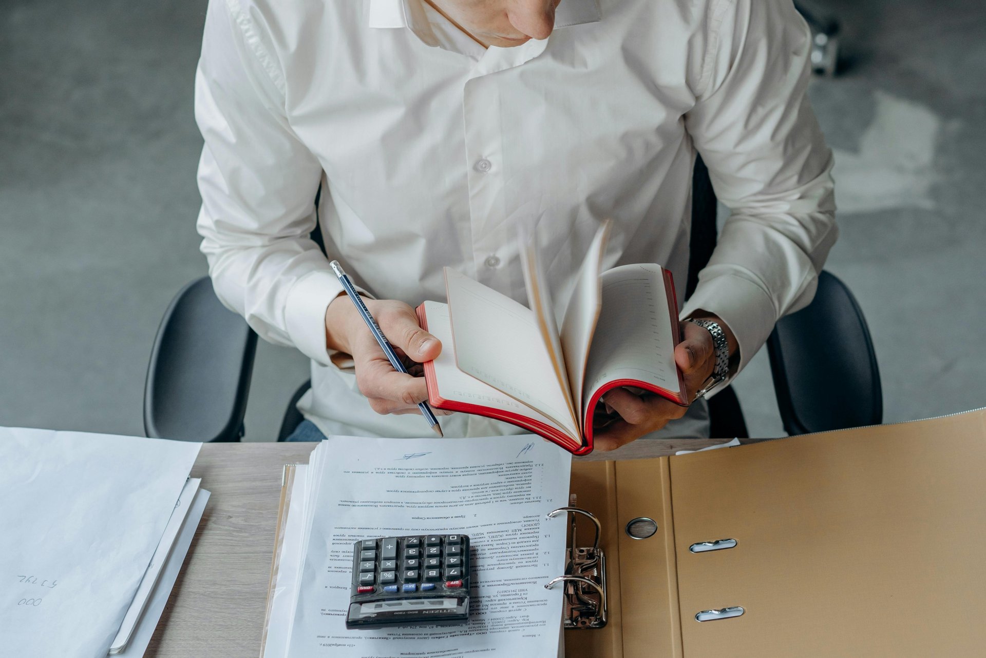 Mężczyzna pracujący z dokumentami w biurze, jako dopełnienie nagłówka Biura Rachunkowego Deltaxing.