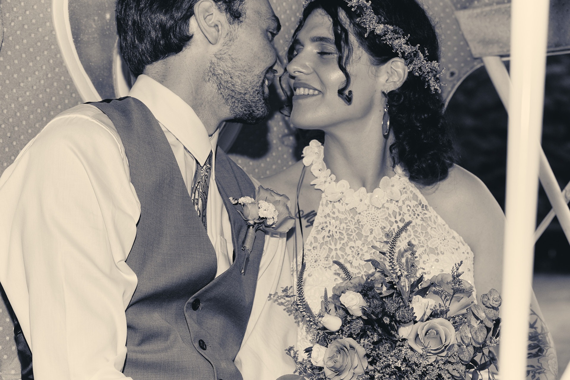 a bride and a groom kissing and smiling at each other in a carriage
