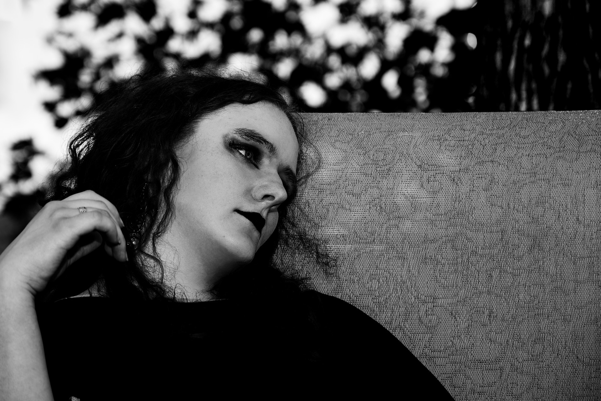 a woman with long hair and a black shirt sitting outdoor