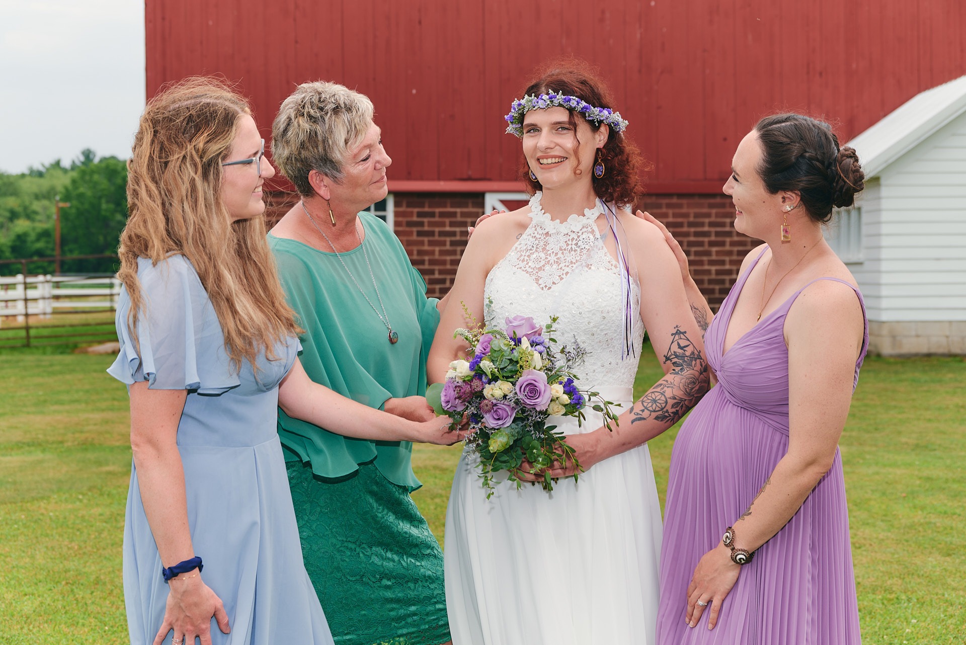 a bride and her bridesmaids are standing in front of a barn