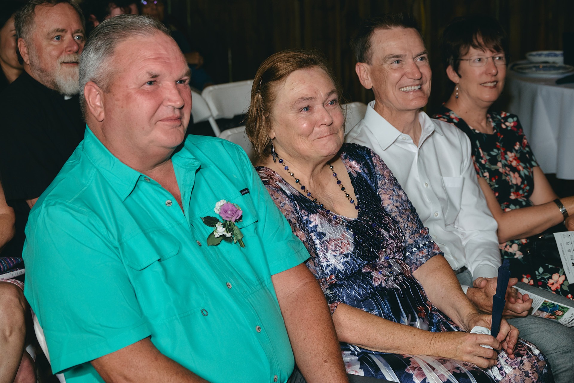a group of people sitting in chairs at a wedding and a woman crying