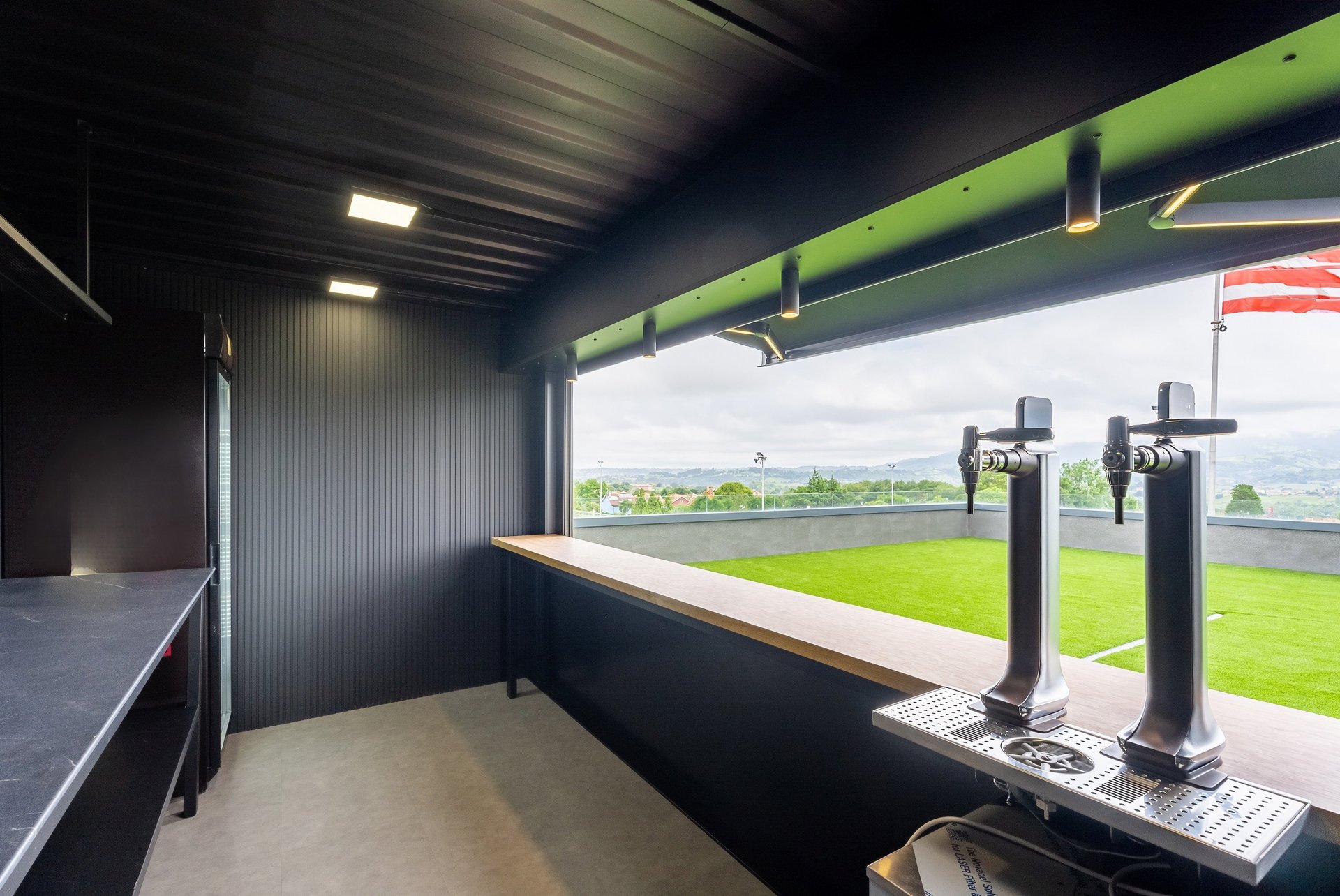 Interior de módulo de eventos con barra y grifos de cerveza