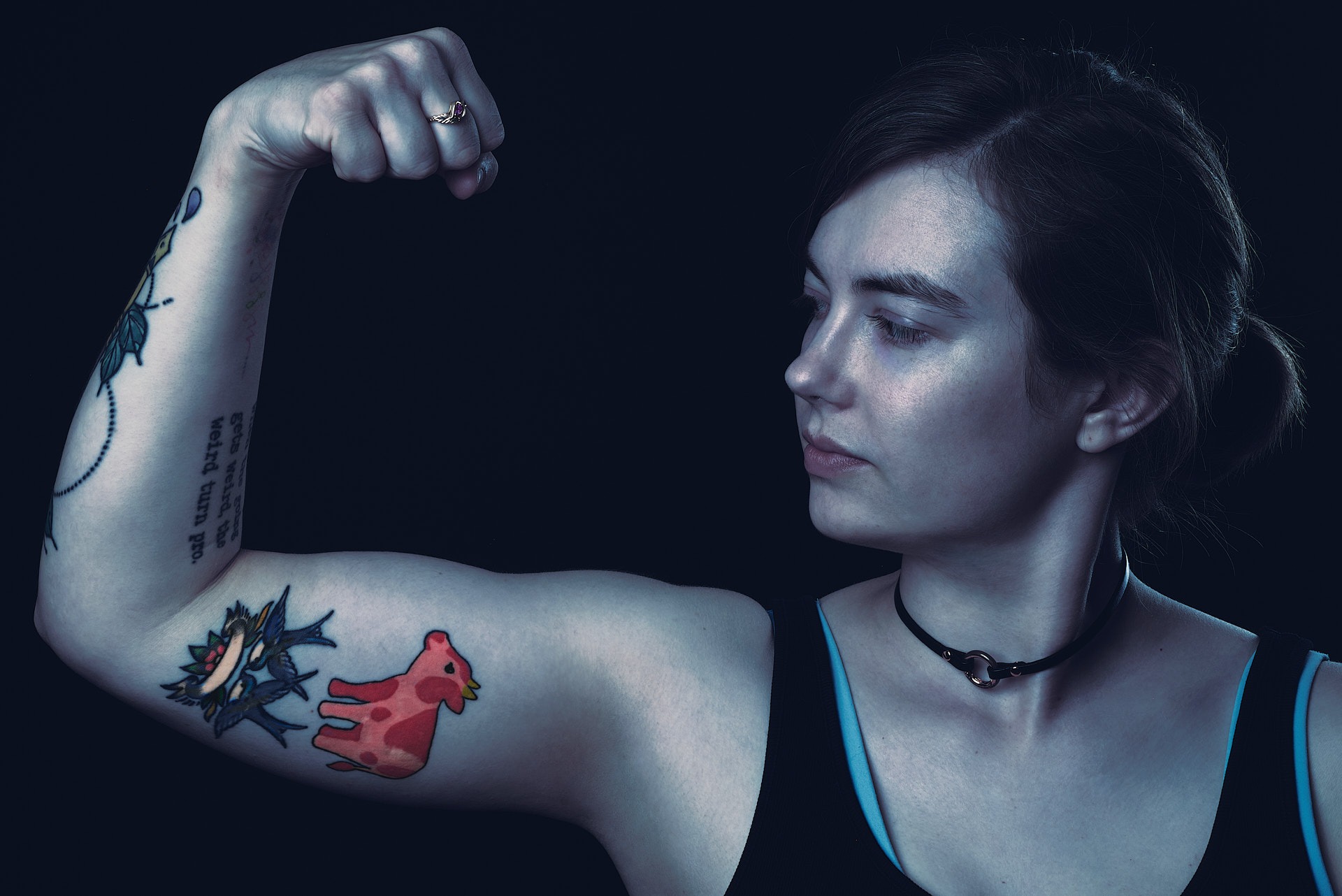 a woman with cow tattoos on her arm in a dark mood environment