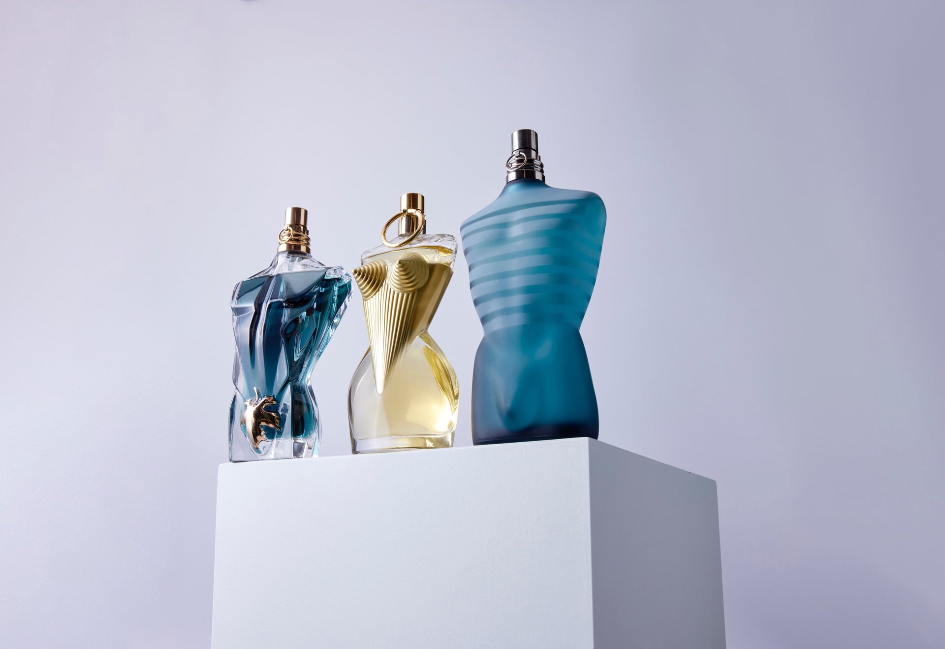 Product Photography of sculptural fragrance bottles on a minimalist pedestal, capturing luxury glass