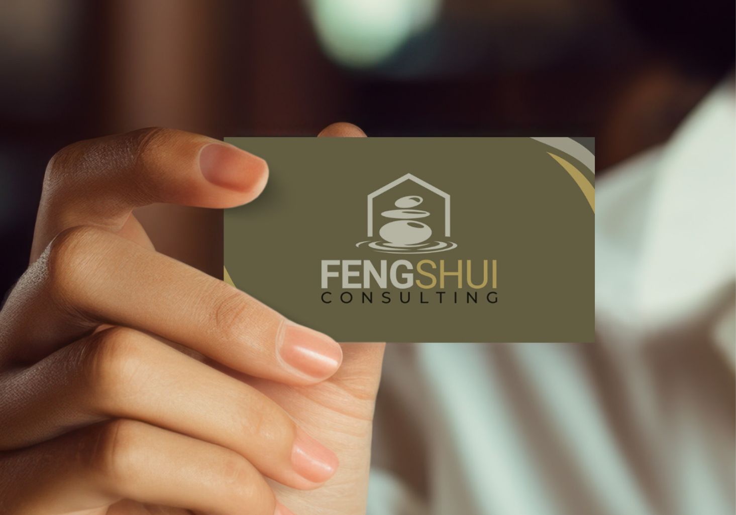 Une main tenant une carte de visite de consultant feng shui arborant un logo en pierre zen