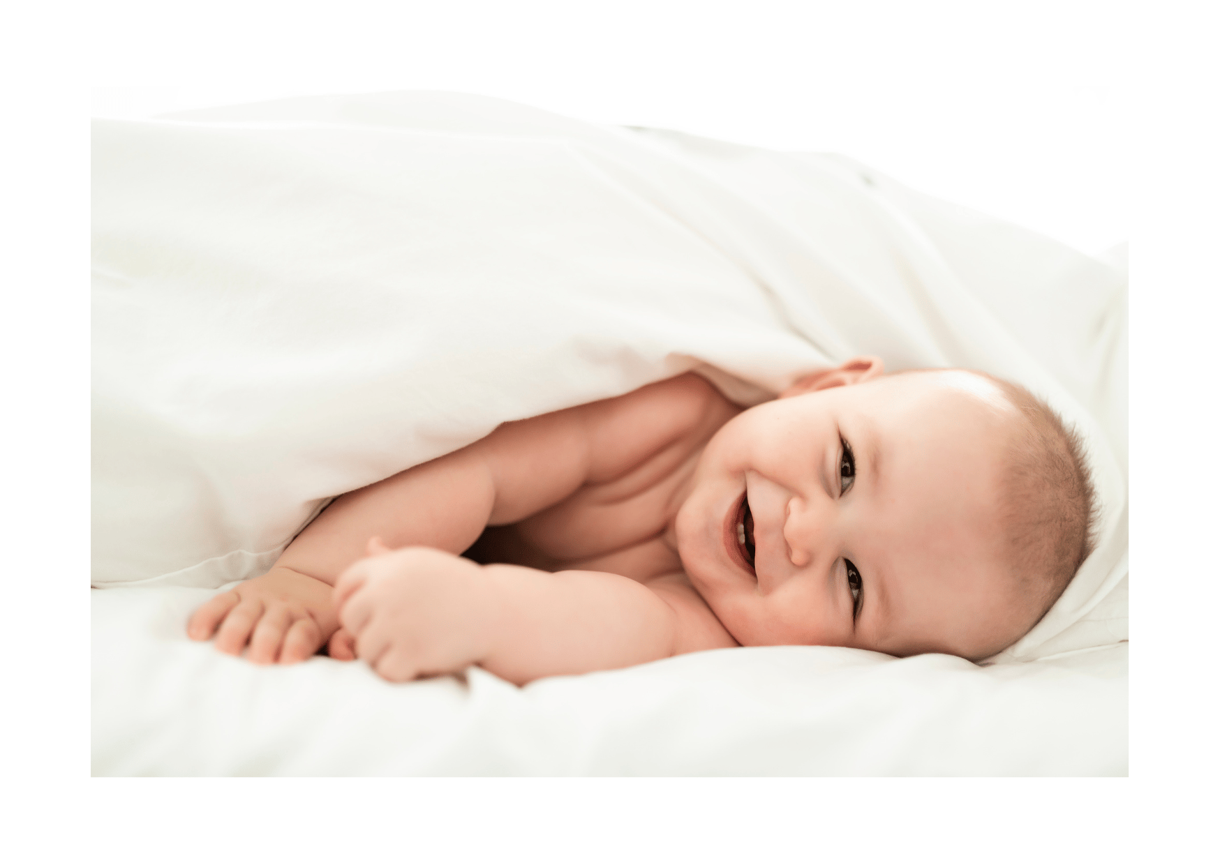 a baby is smiling and laying down on a bed