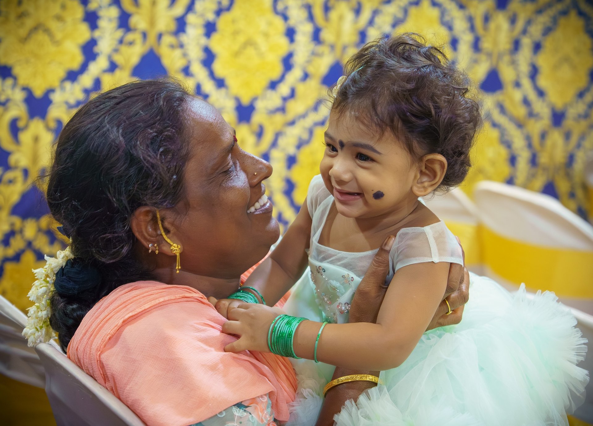 A mother sharing a joyful candid moment with her baby at an event photographed by Memories and More 