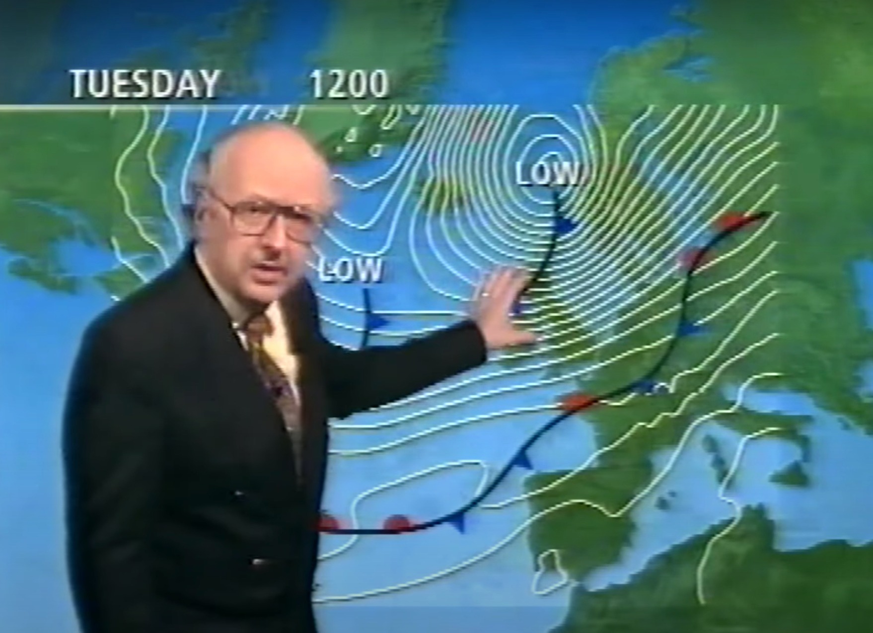 a man in a suit and tie is showinig a weather map