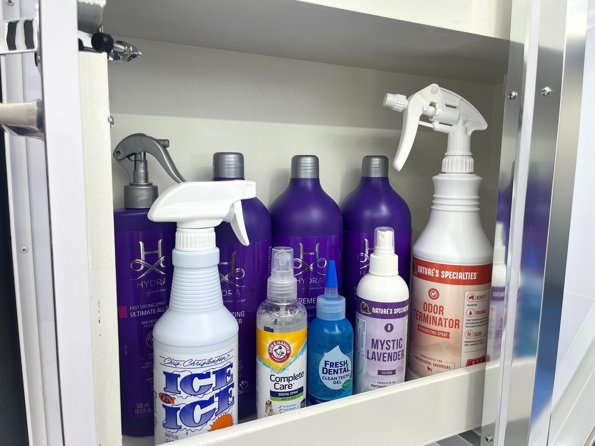 Premium dog shampoos, conditioners, cologne, dental care, and grooming products stocked inside a van