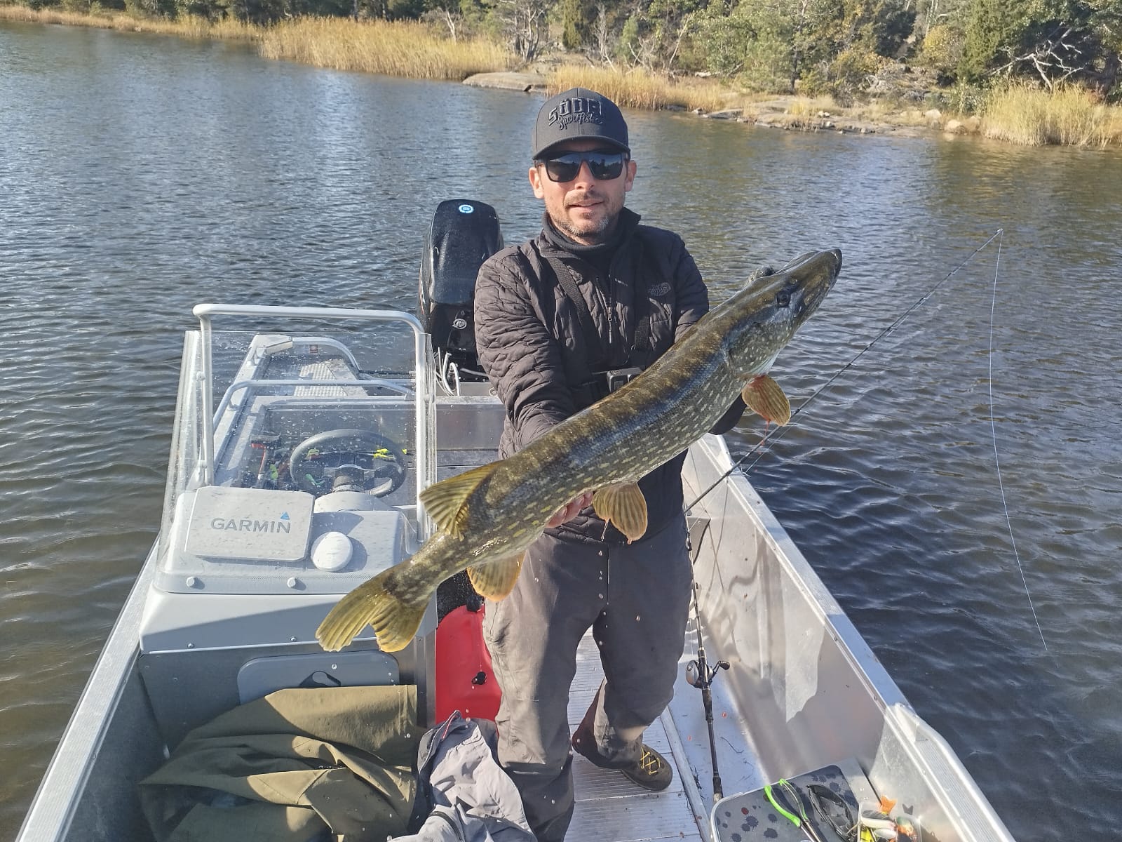 un pêcheur est sur un bateau de pêche , le bateau est un "linder 460". il a beau brochet en suede. .