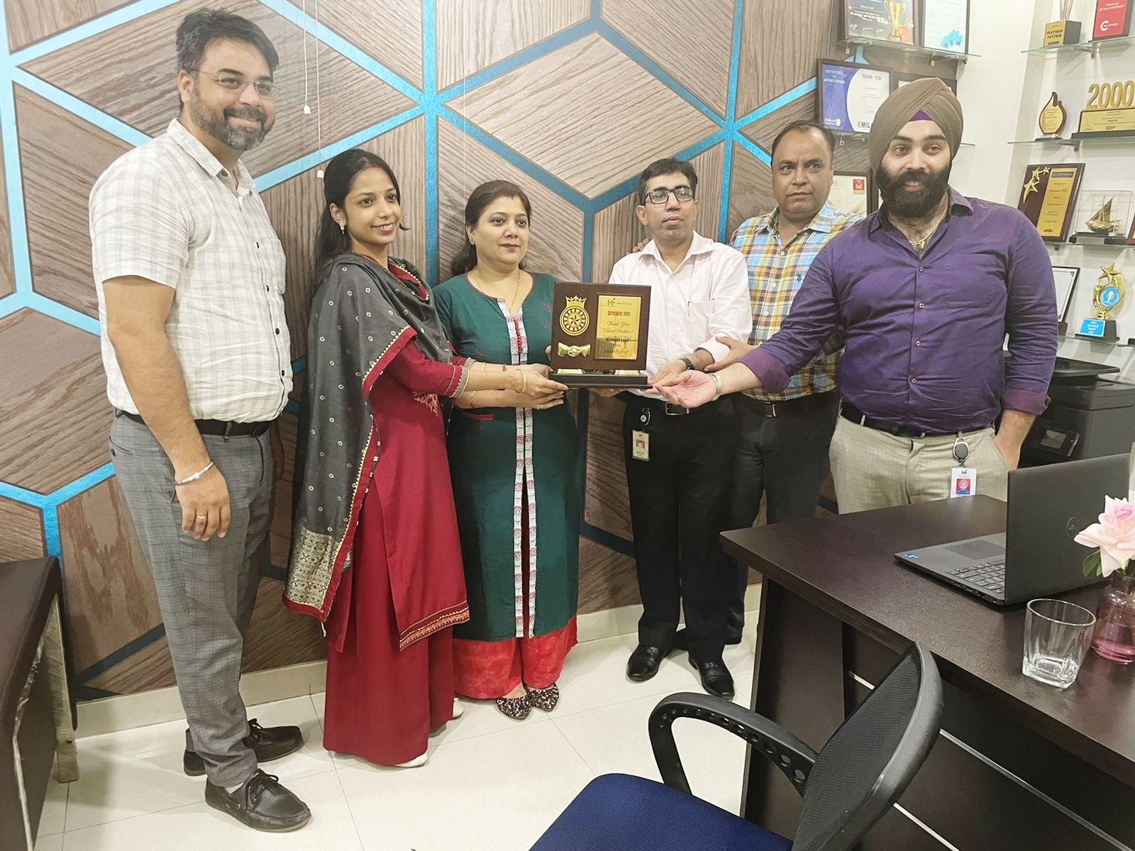 a group of people standing around a desk