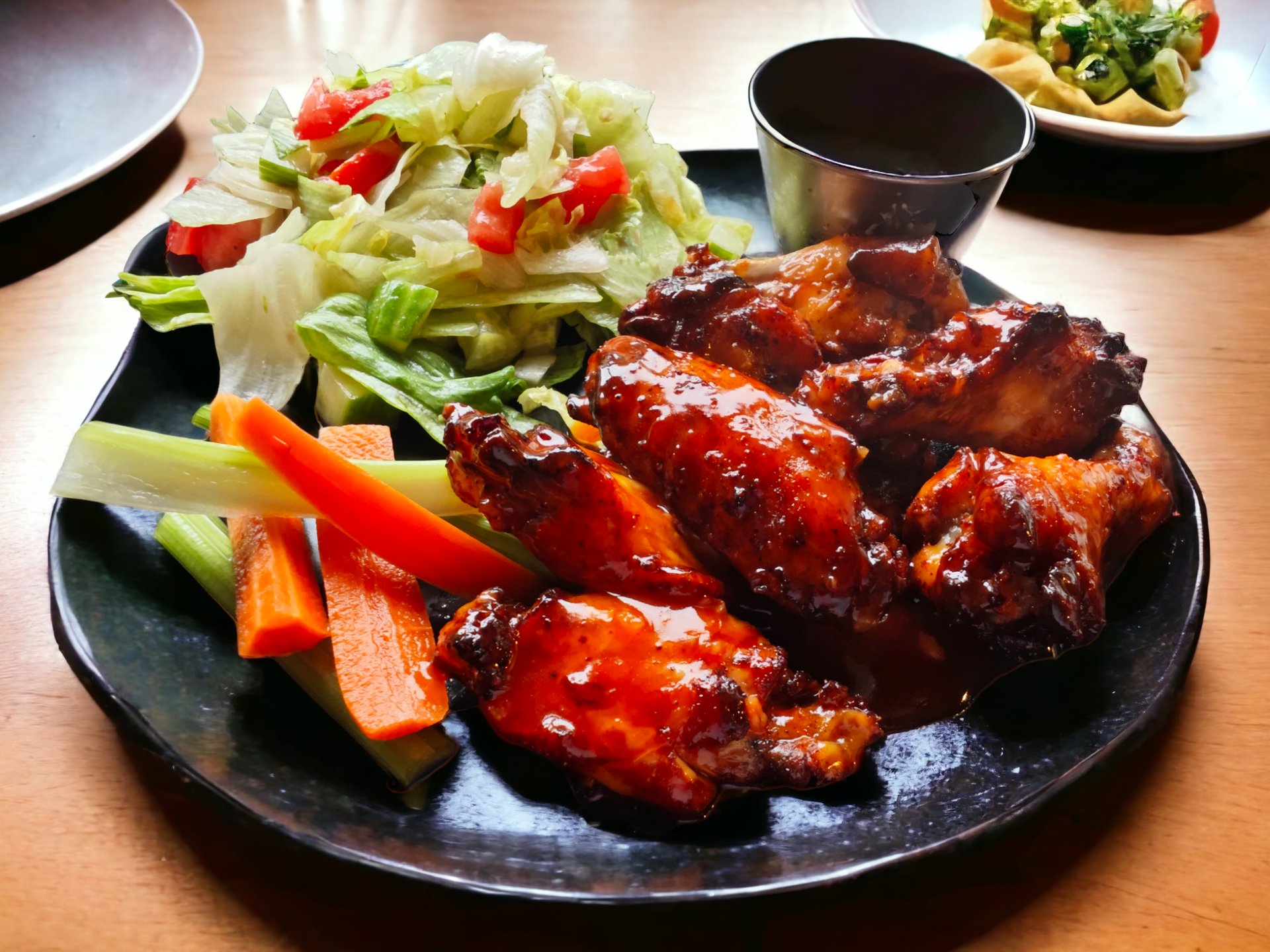 talíř s kuřecími křídly a salátem