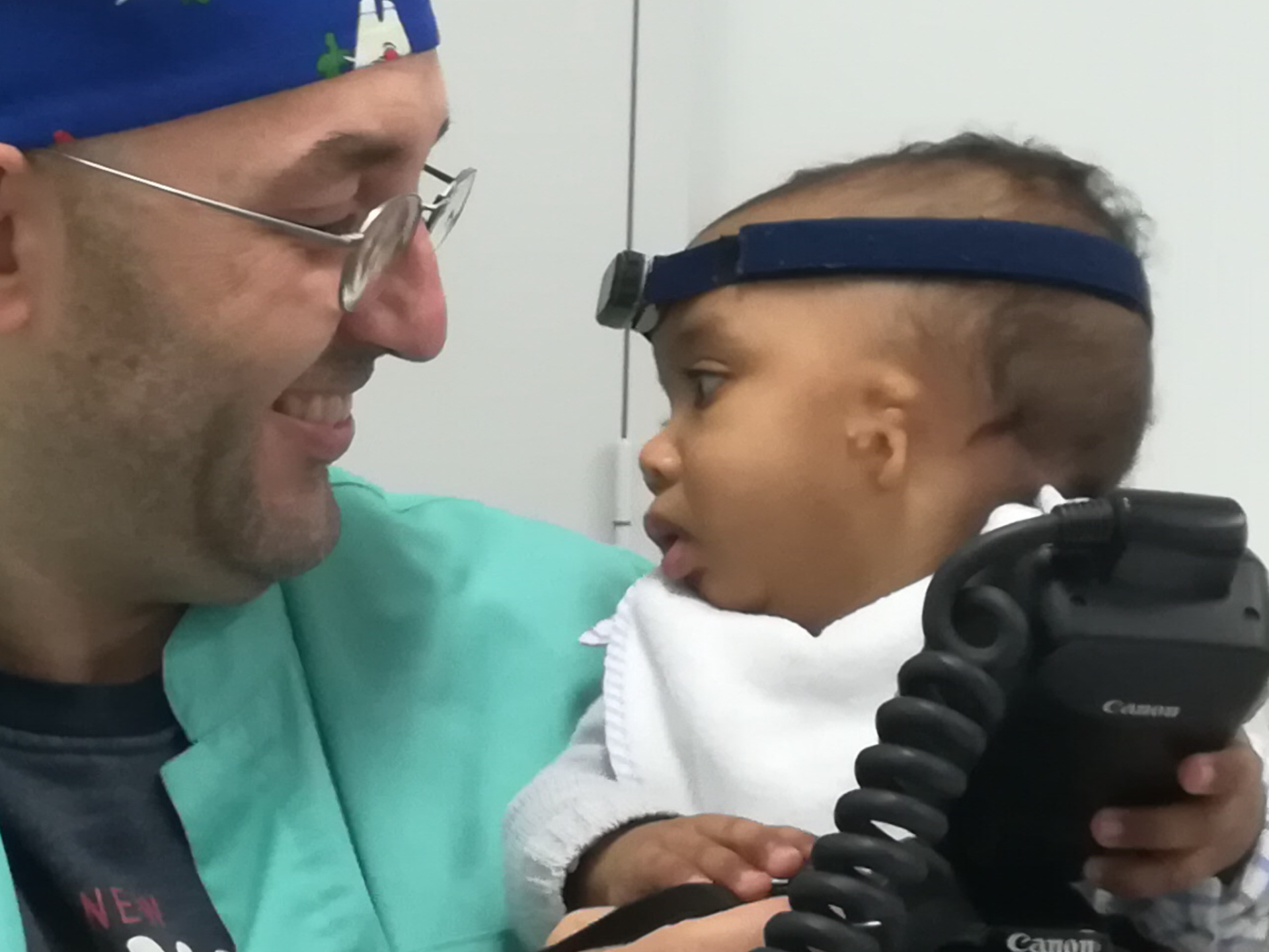 a man in a blue shirt and a baby in a blue hat