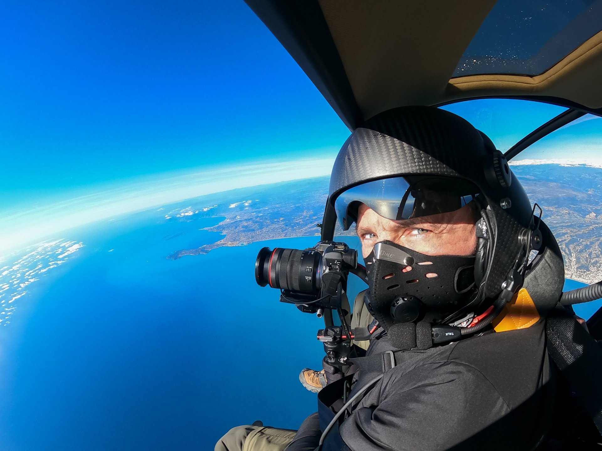 a man in a helmet and goggles is taking a picture of a man in