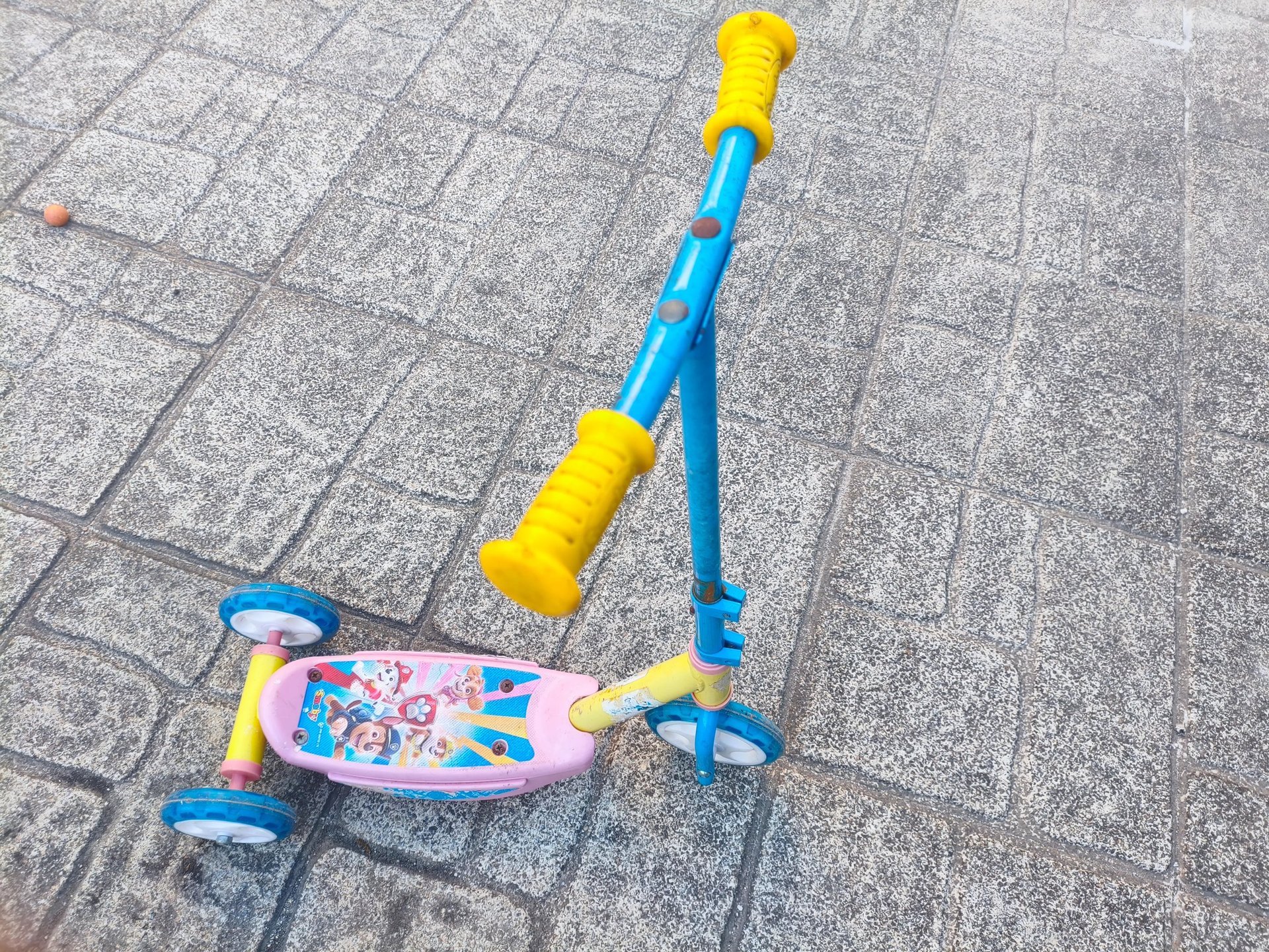 Trotinete 3 rodas Paw Patrol Smobe em azul e rosa com personagens da Patrulha Pata, apoiada no chão 