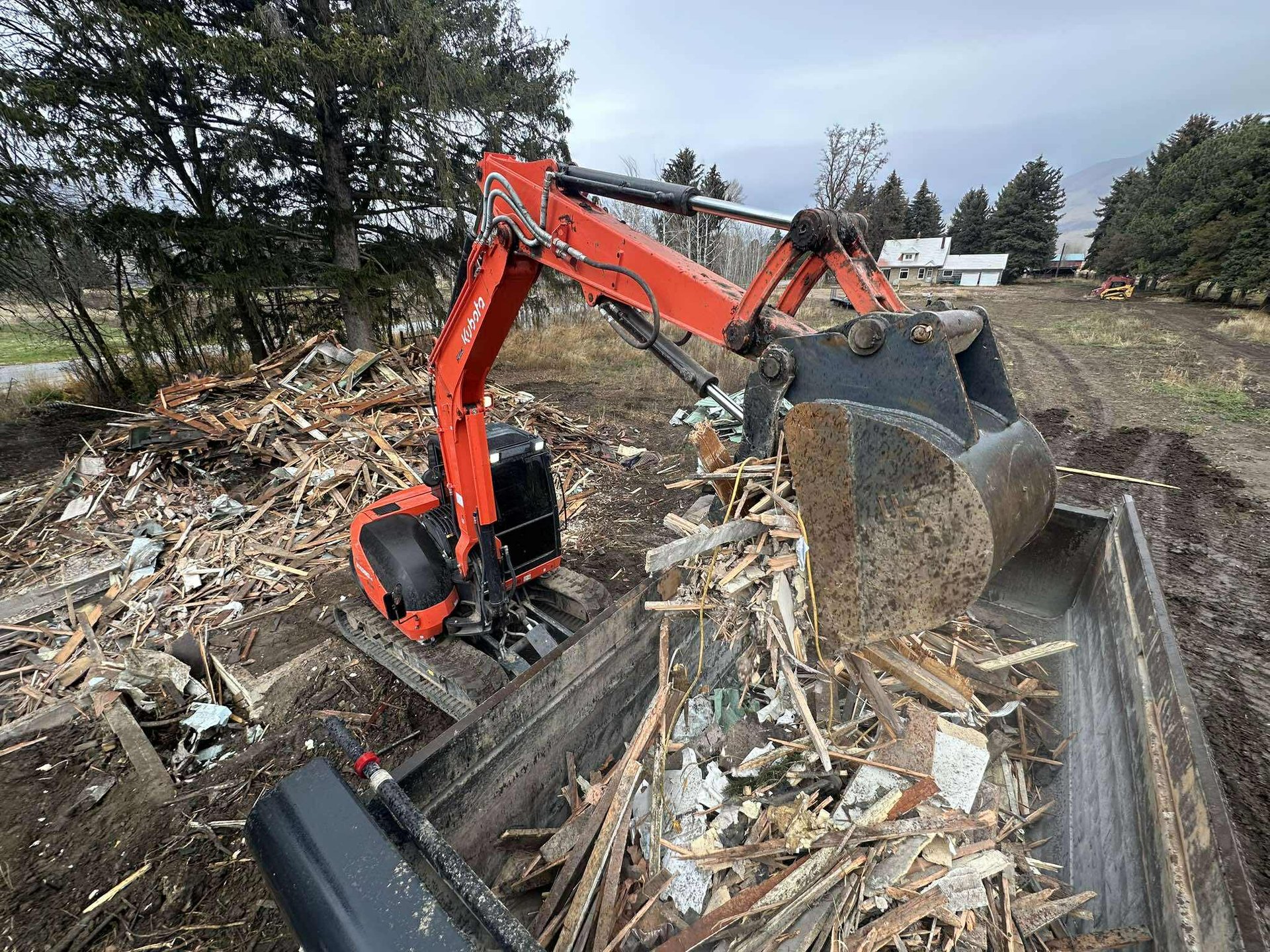Kubota loading debris from demolition into dump truck