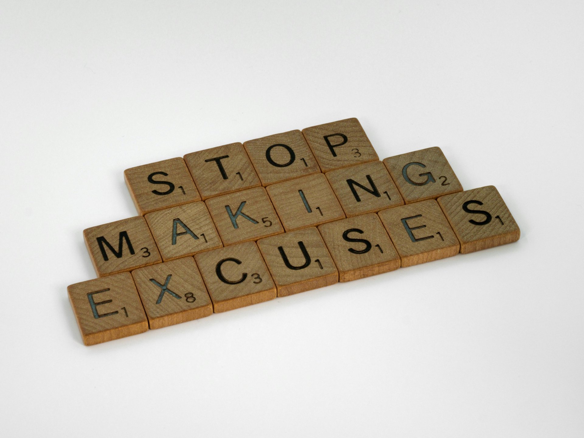 a wooden block with words that spell out the word stop making excuses