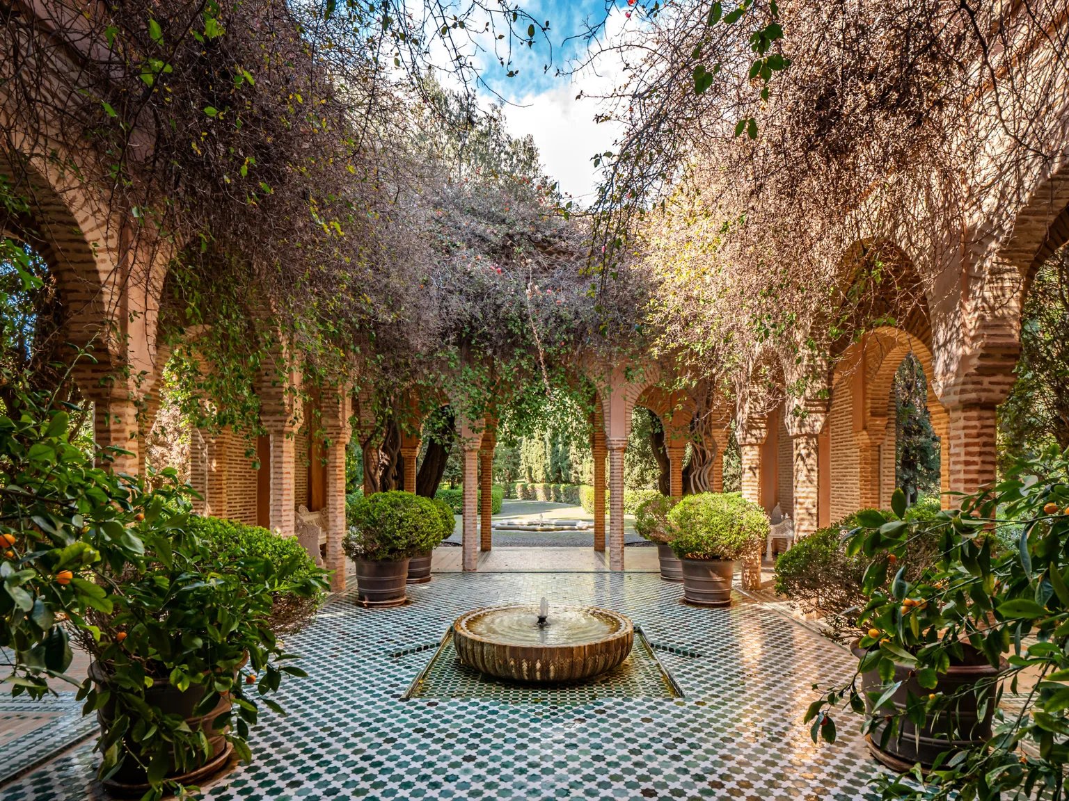 Arched brick colonnade with tiled floor and central fountain