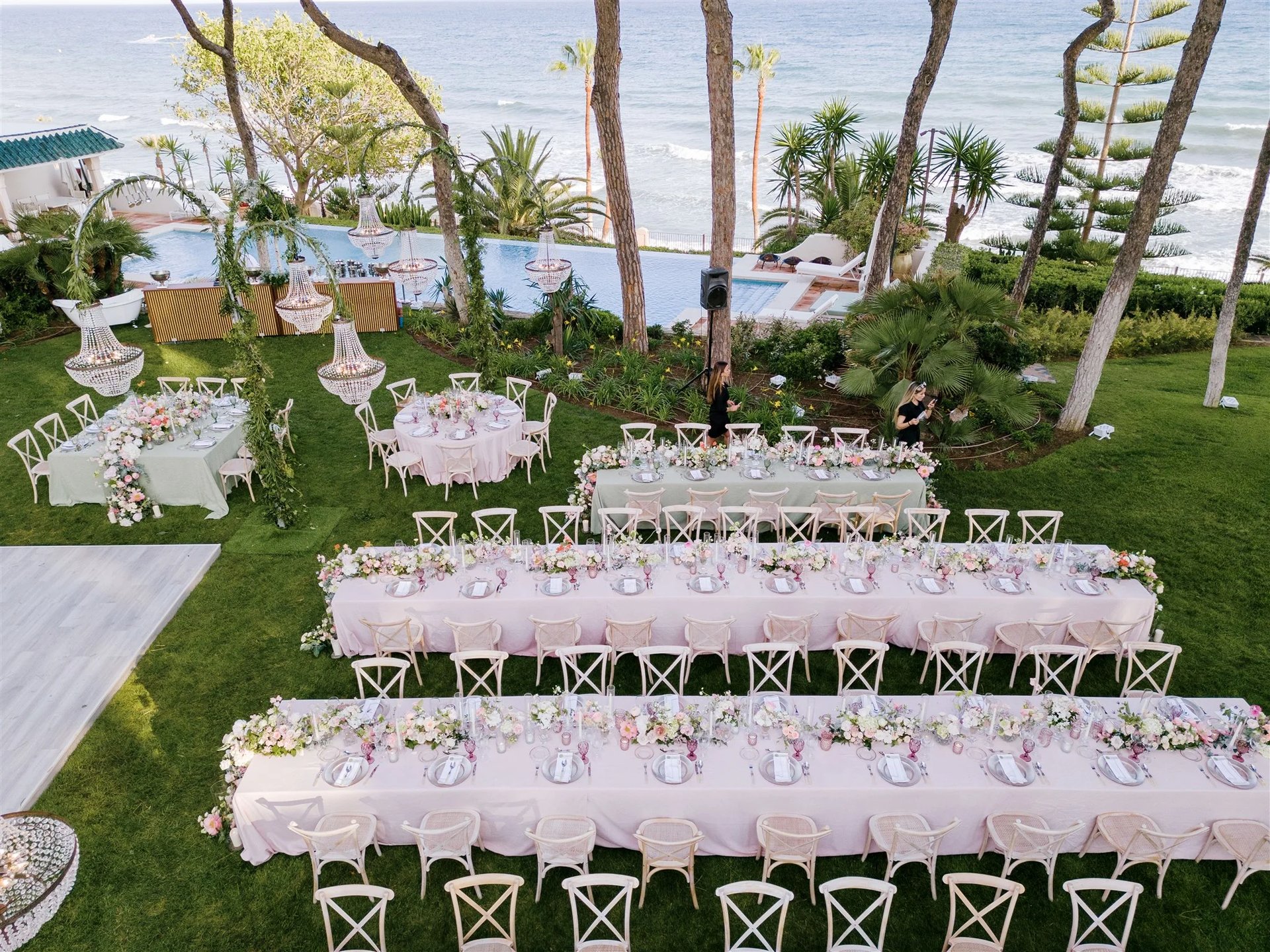 Seafront wedding dinner setup beside infinity pool