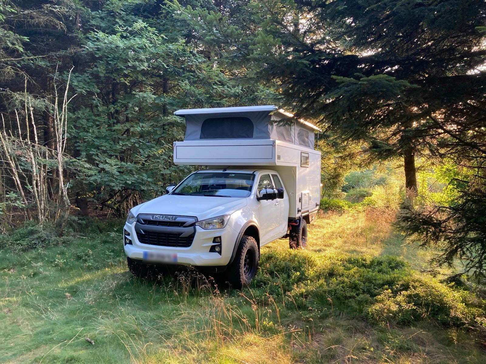 una pick-up camper 4x4 con techo elevable en el bosque