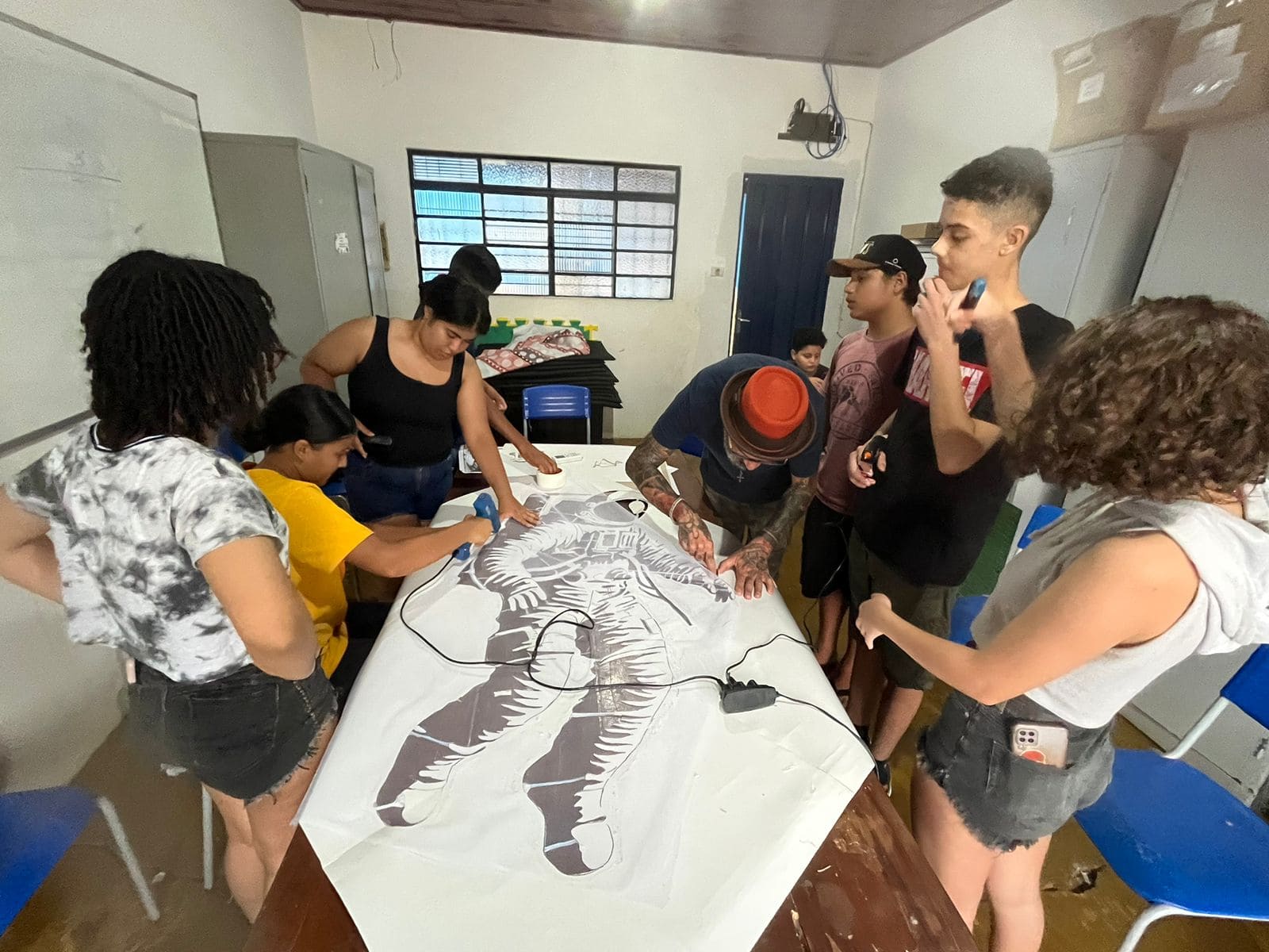 Arte-educador Sérgio Astral auxiliando os alunos.