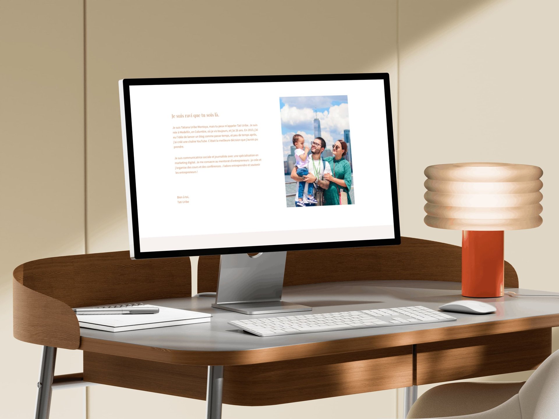 A desktop monitor displaying a professional website on a modern wooden desk with a stylish lamp.