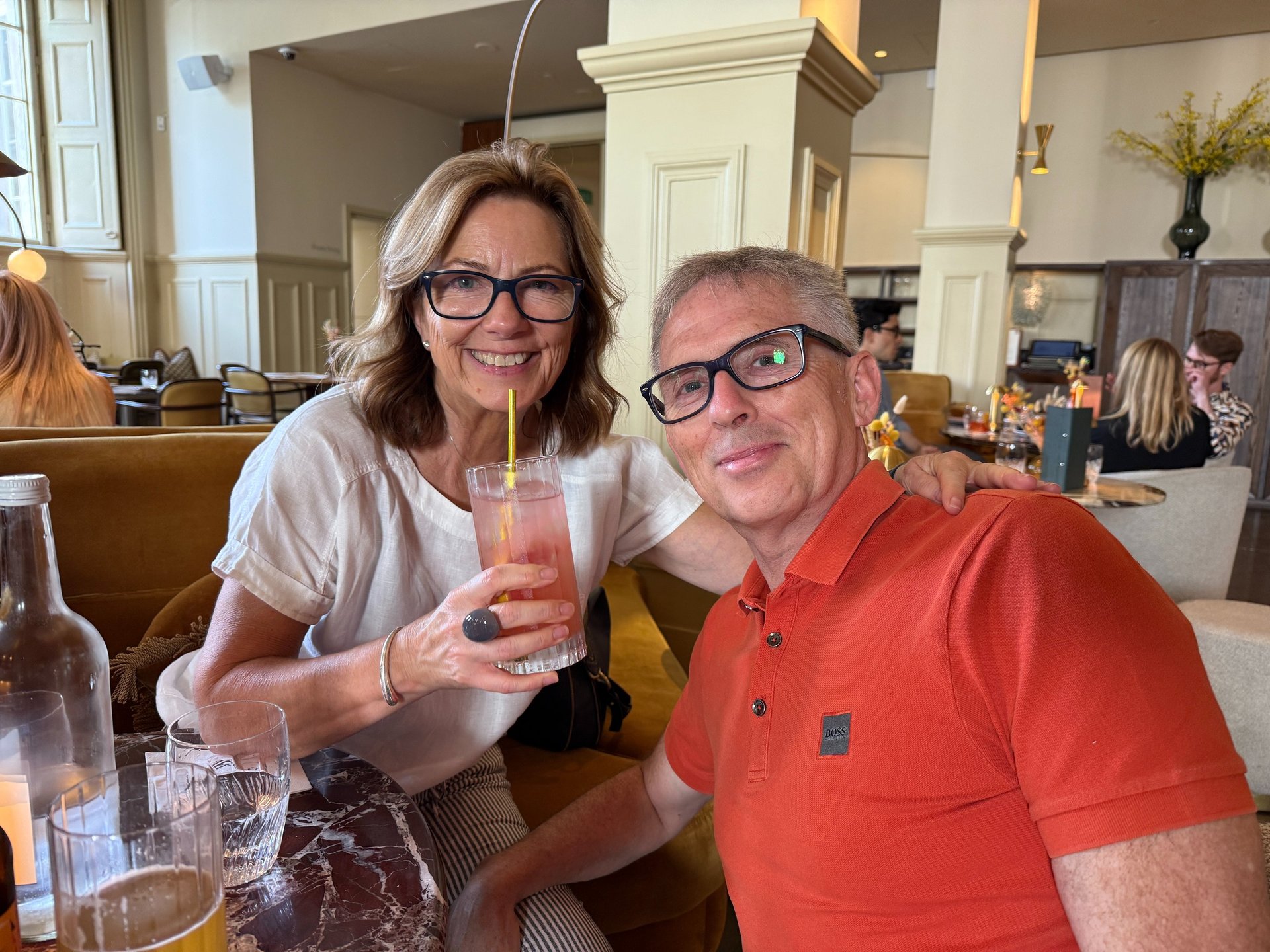 Two adults smiling at restaurant table with drinks and candle, enjoying relaxed social outing