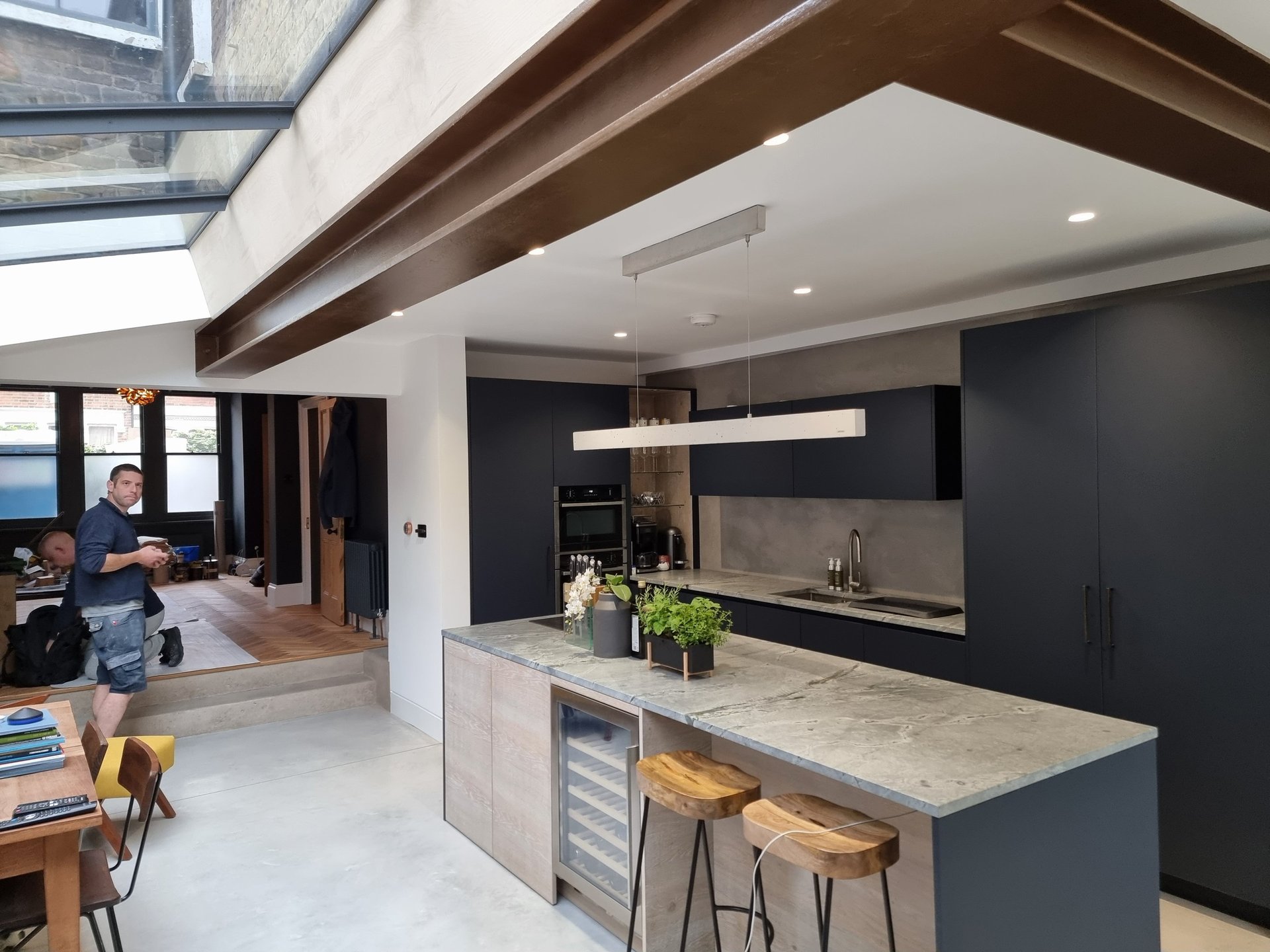 Modern kitchen with matte navy cabinets and exposed beams, painted by Pure Perfection on Balham