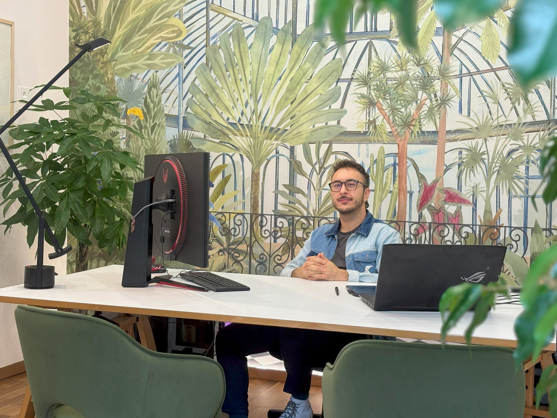 the owner sitting at the desk of the studio with his computer
